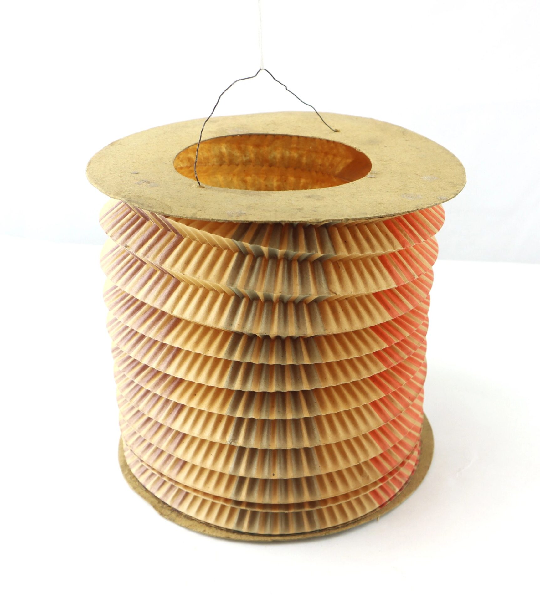 The Political Parade Lantern features a cylindrical shape with pleated sides, sturdy cardboard top and bottom, and a thin wire handle for hanging.