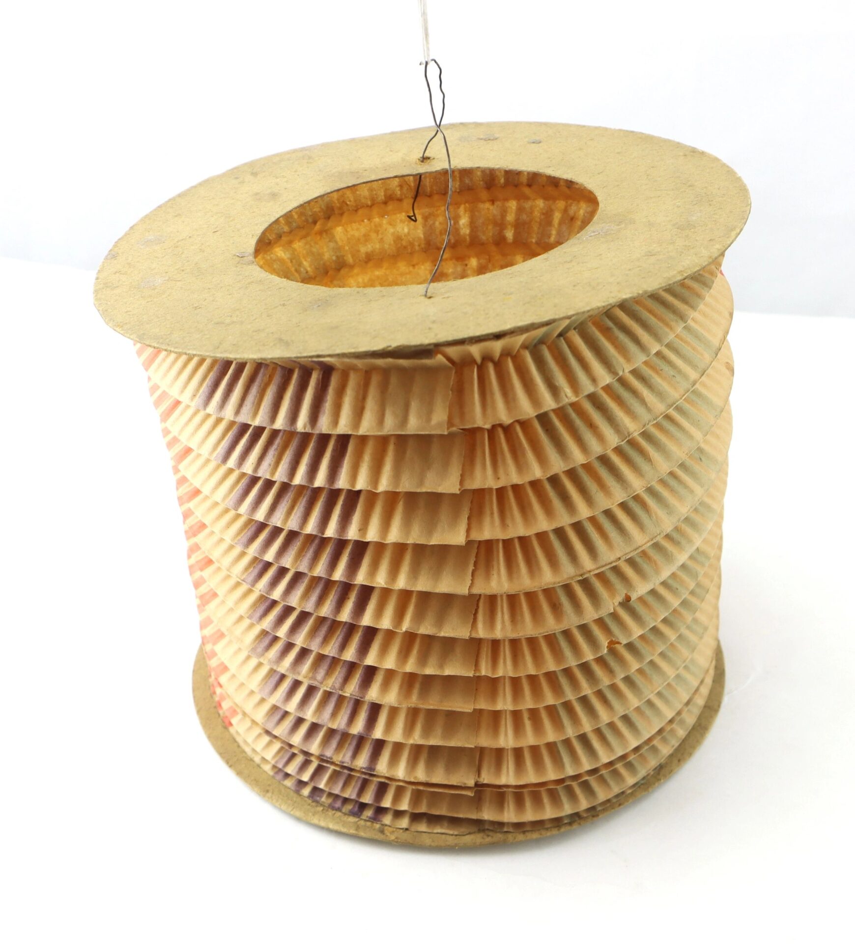 A Political Parade Lantern featuring a stack of brown cupcake liners arranged in a tall, round spool with a cardboard base and top, all held together by a piece of wire.