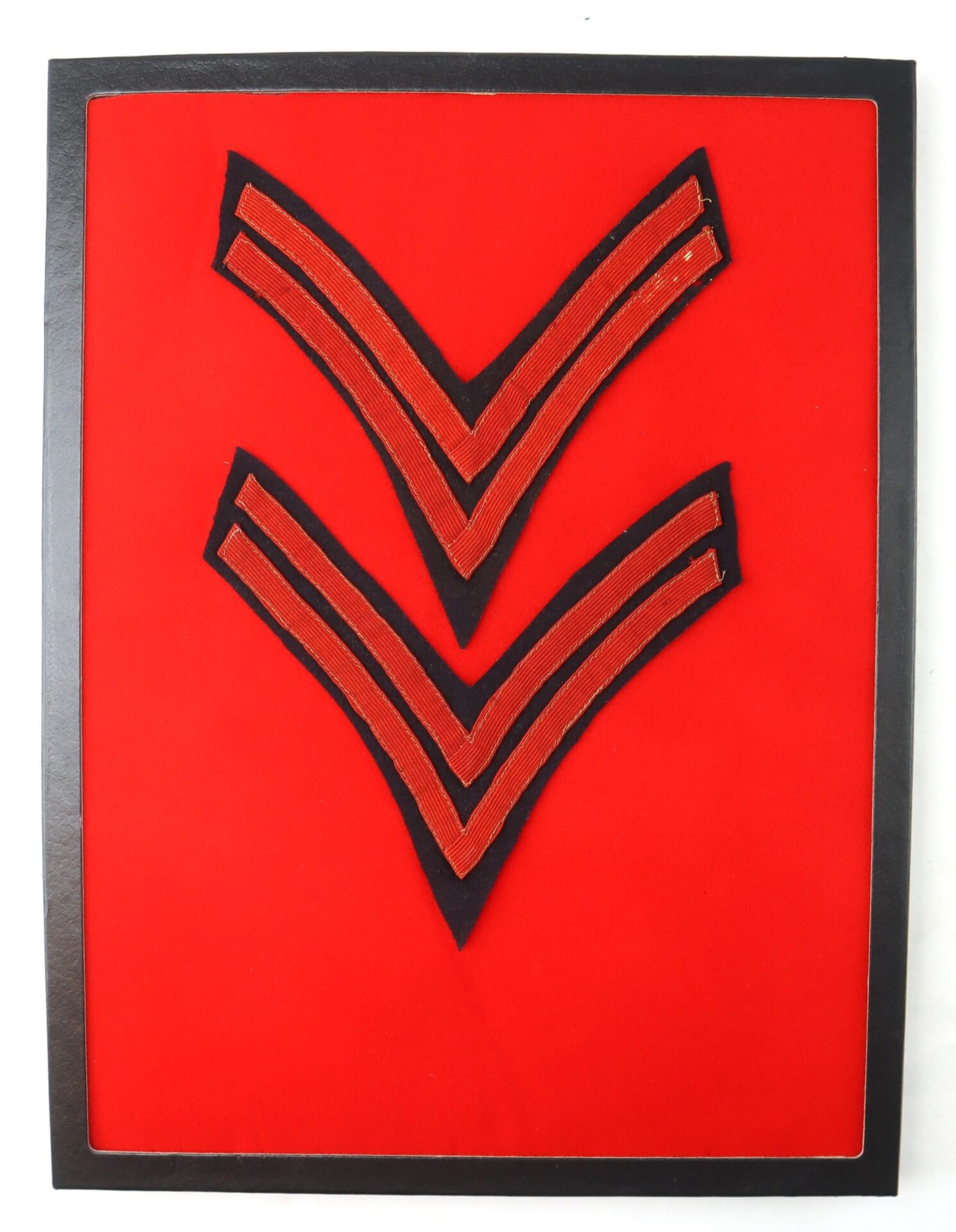 A framed display of Original Civil War Federal Regulation Chevrons: two artillery corporal V-shaped chevrons, each with two red stripes, mounted on a bright red background.