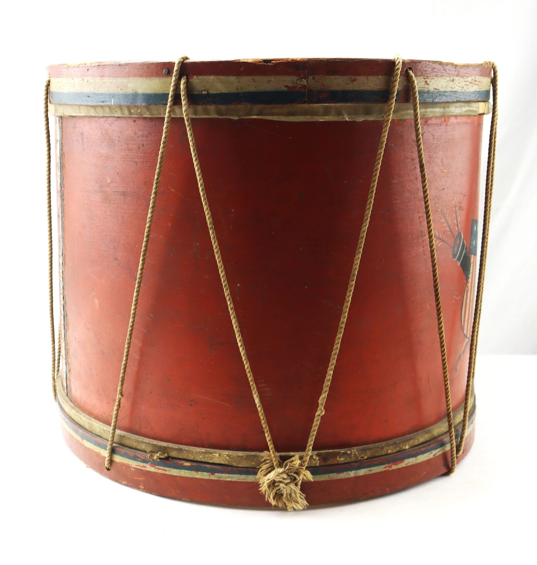The Civil War Painted Drum is a large vintage red drum with faded paint, rope tensioning, and brass rims, photographed against a plain white background.