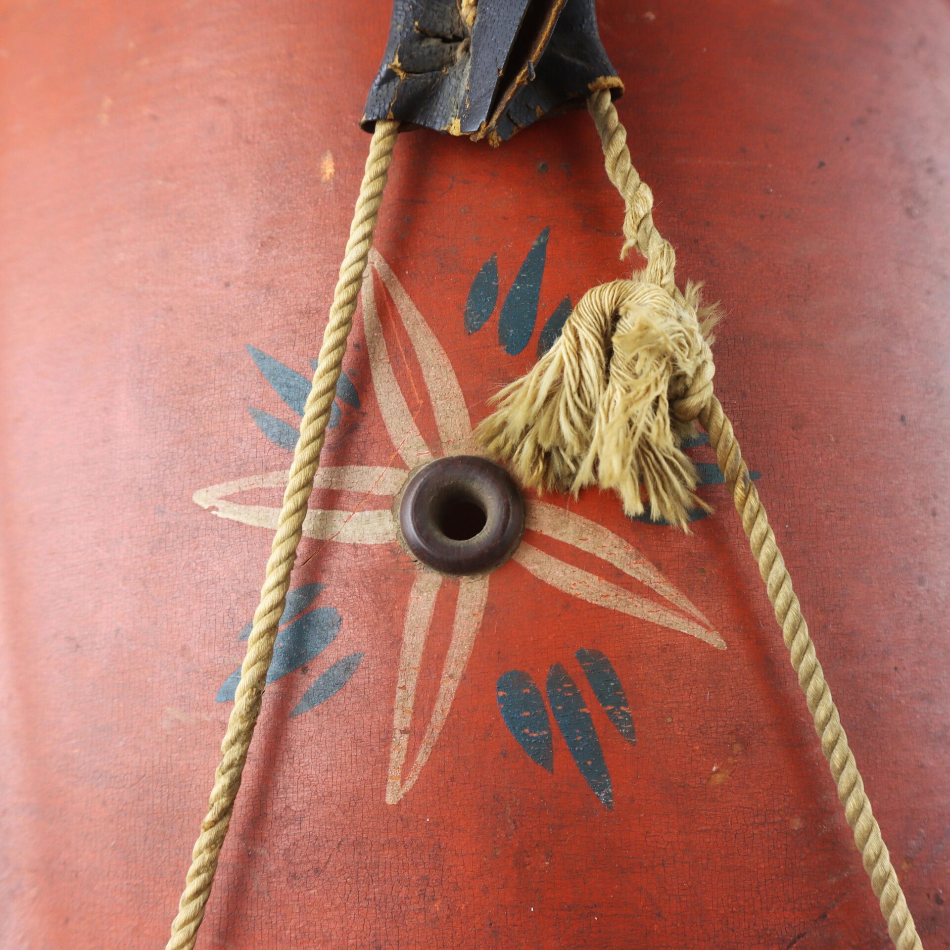 Close-up of the Civil War Painted Drum featuring a floral design, worn rope, and a central metal eyelet.