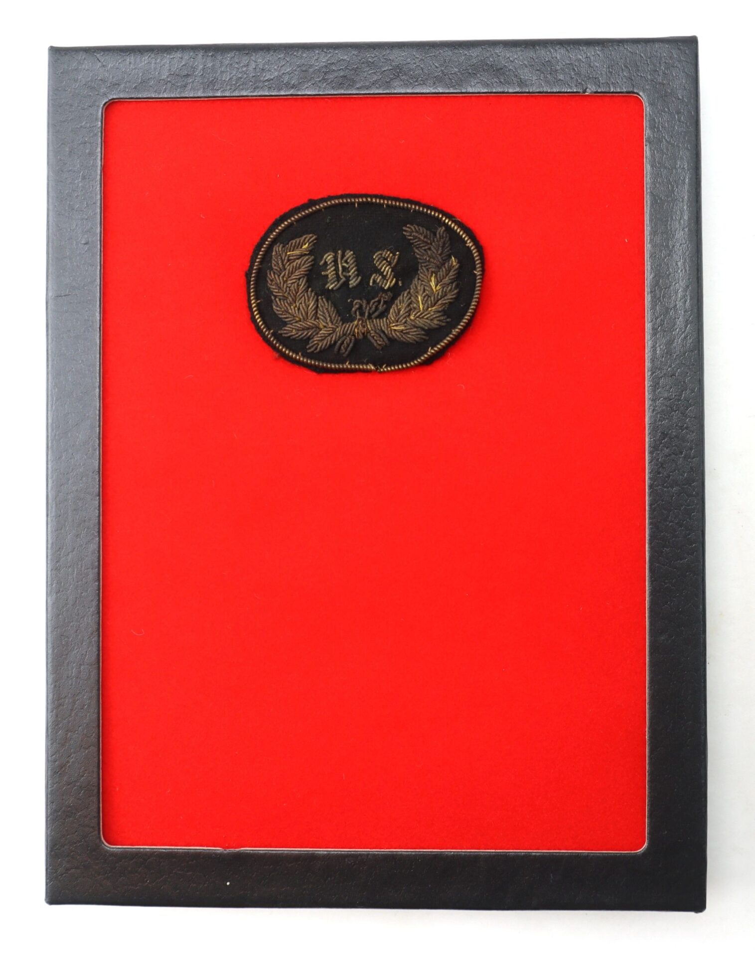 The Civil War U.S. Staff Wreath Hat Insignia features a black frame with a red background, displaying a black oval patch adorned with gold-embroidered "442" and laurel leaves.