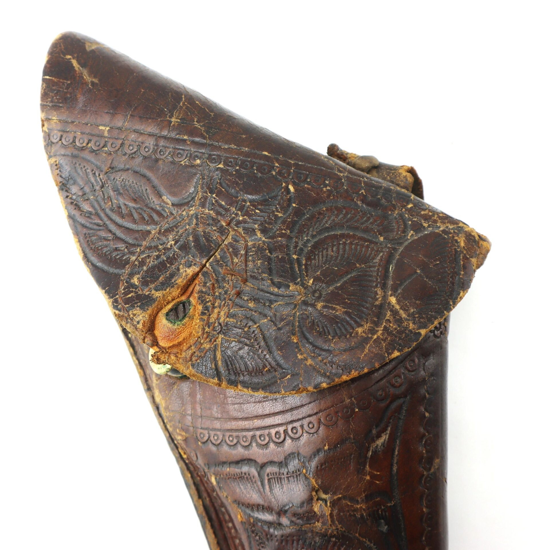 Close-up of the Wonderful “Rose of Texas” Holster, featuring worn brown leather with decorative floral embossing and visible cracks.