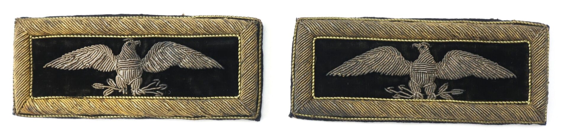 A pair of Colonel of Staff Shoulder Bars: rectangular black fabric patches featuring gold embroidered eagles and gold-thread borders, likely military insignia.