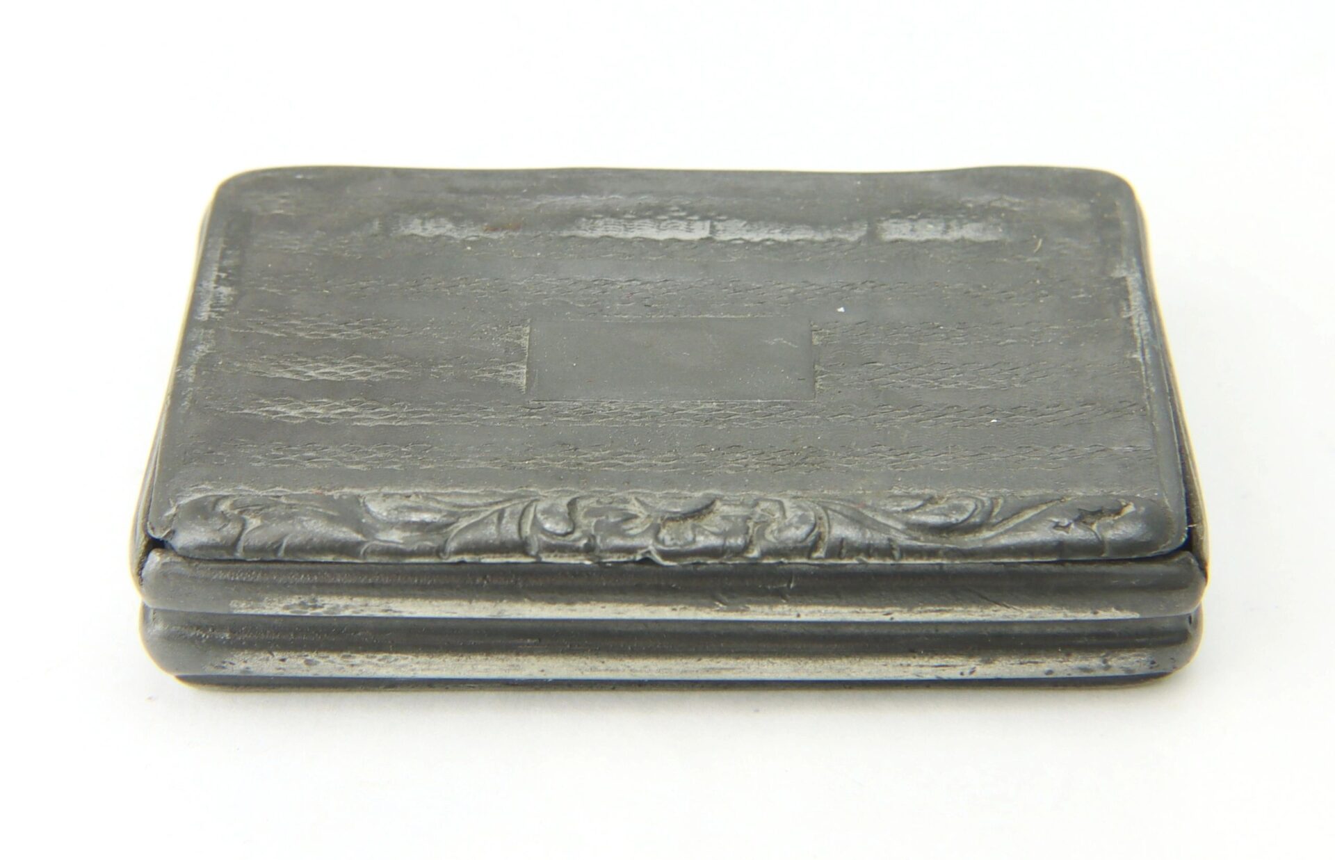 A Civil War snuff box, rectangular and dark-colored with a flat lid and subtle ornate detailing along the front edge, is photographed against a plain white background.
