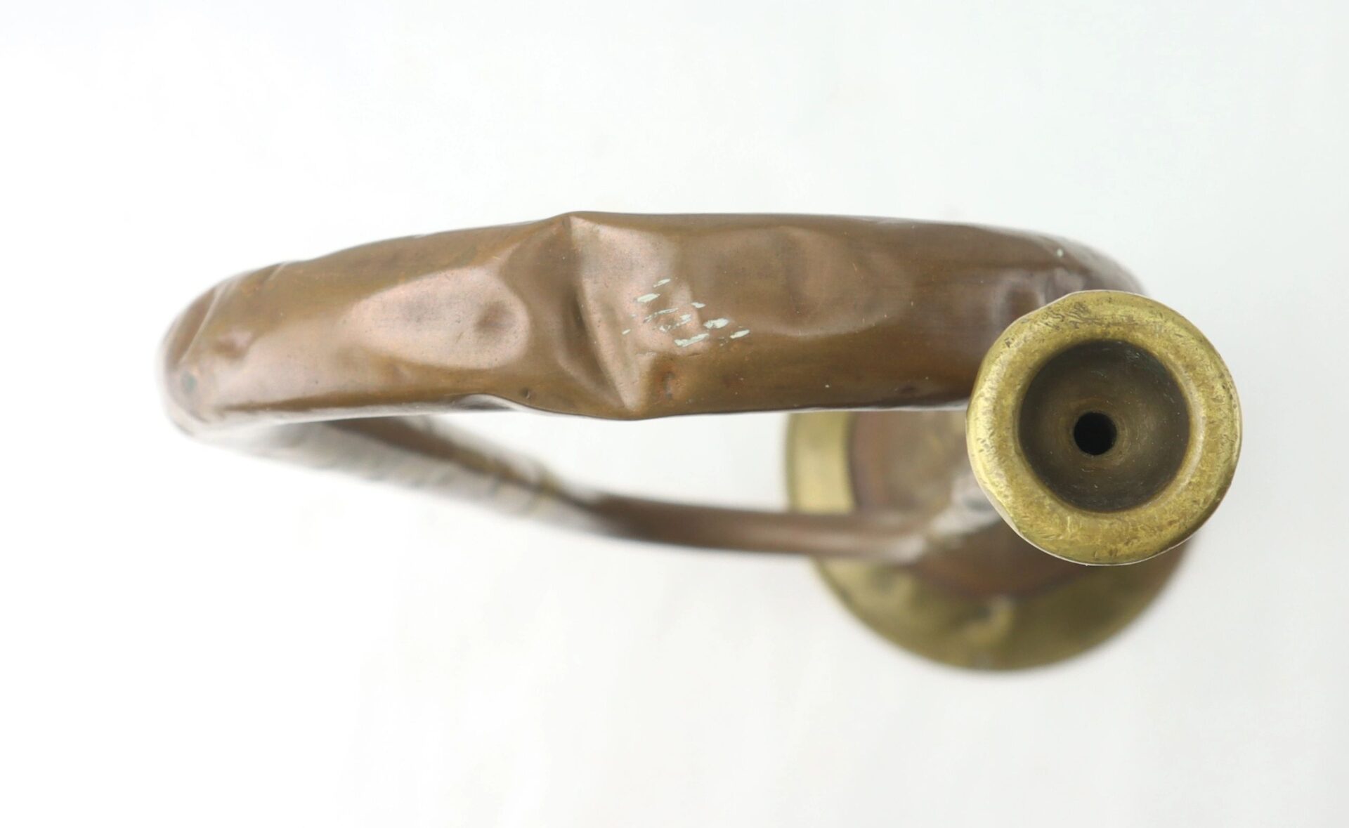 A close-up, top view of a dented, tarnished Civil War Bugle against a plain white background.