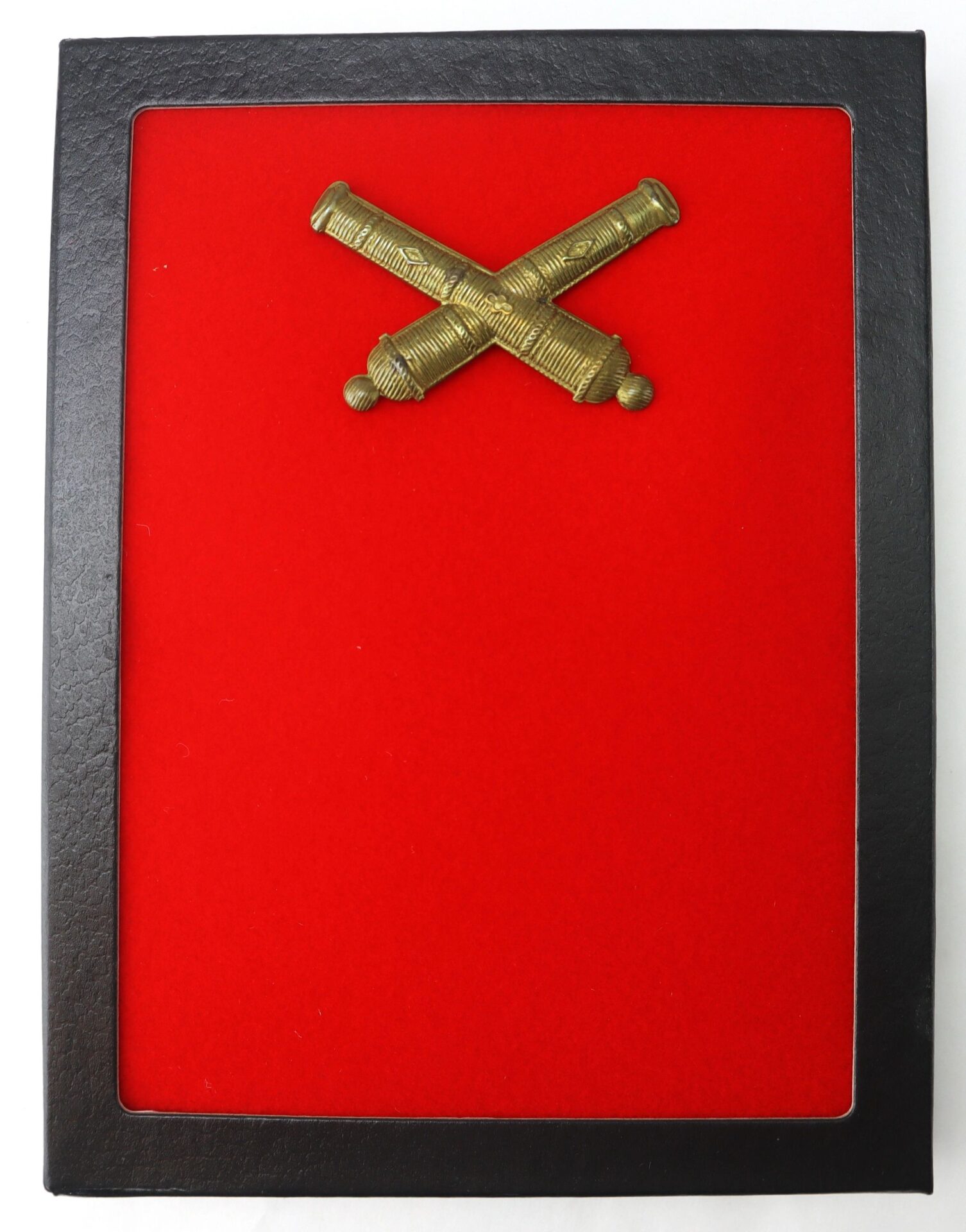 A black frame with a red felt background displays two crossed brass cannons at the top center, showcasing the Officer’s False Embroidered Artillery Insignia (SOLD).
