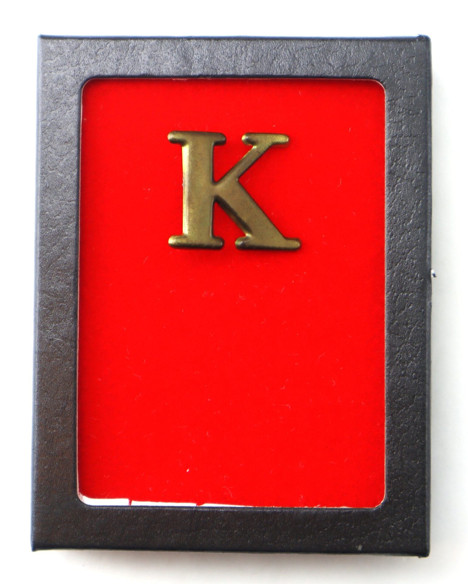 The Original Civil War Brass Hat Letter “K” Company Designation features a brass "K" on a red background, framed in black.