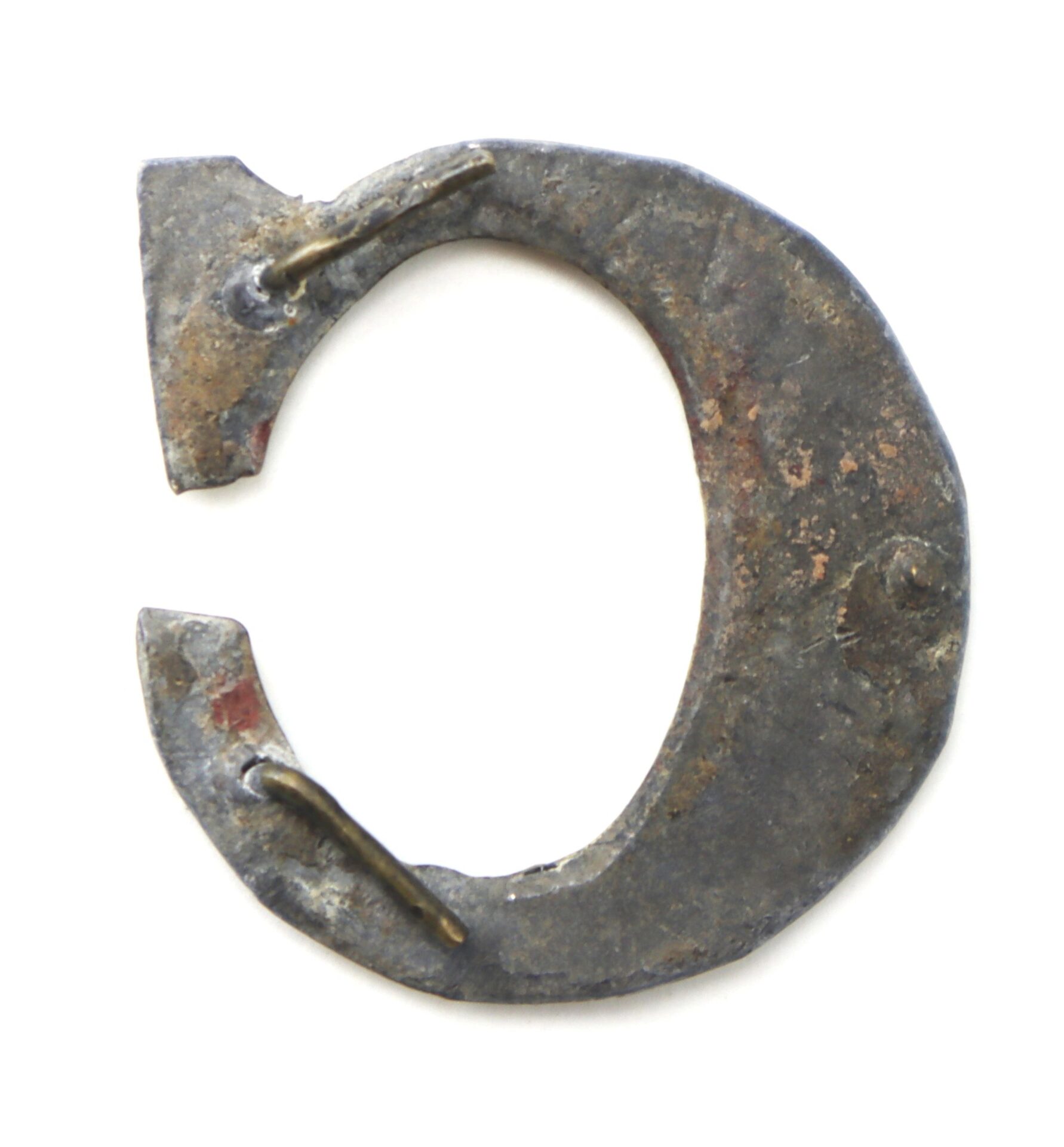 A weathered, brass Civil War hat letter “C” company designation with a gap at the top, displayed against a white background.