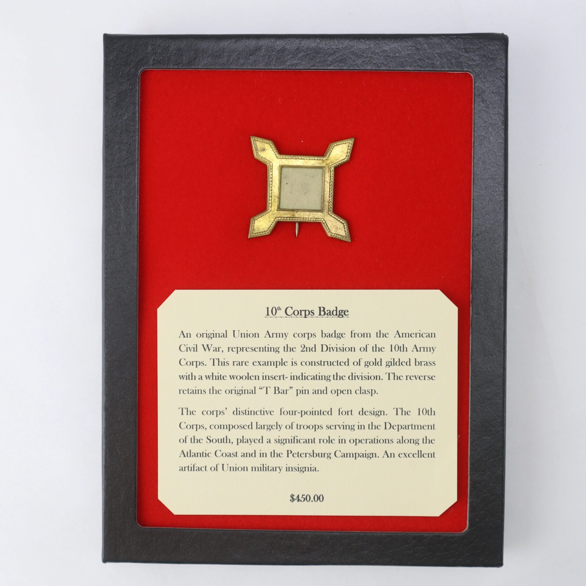 The 10th Corps Badge is a framed Union Army artifact from the Civil War, mounted on red felt with a descriptive plaque, offered at $450.