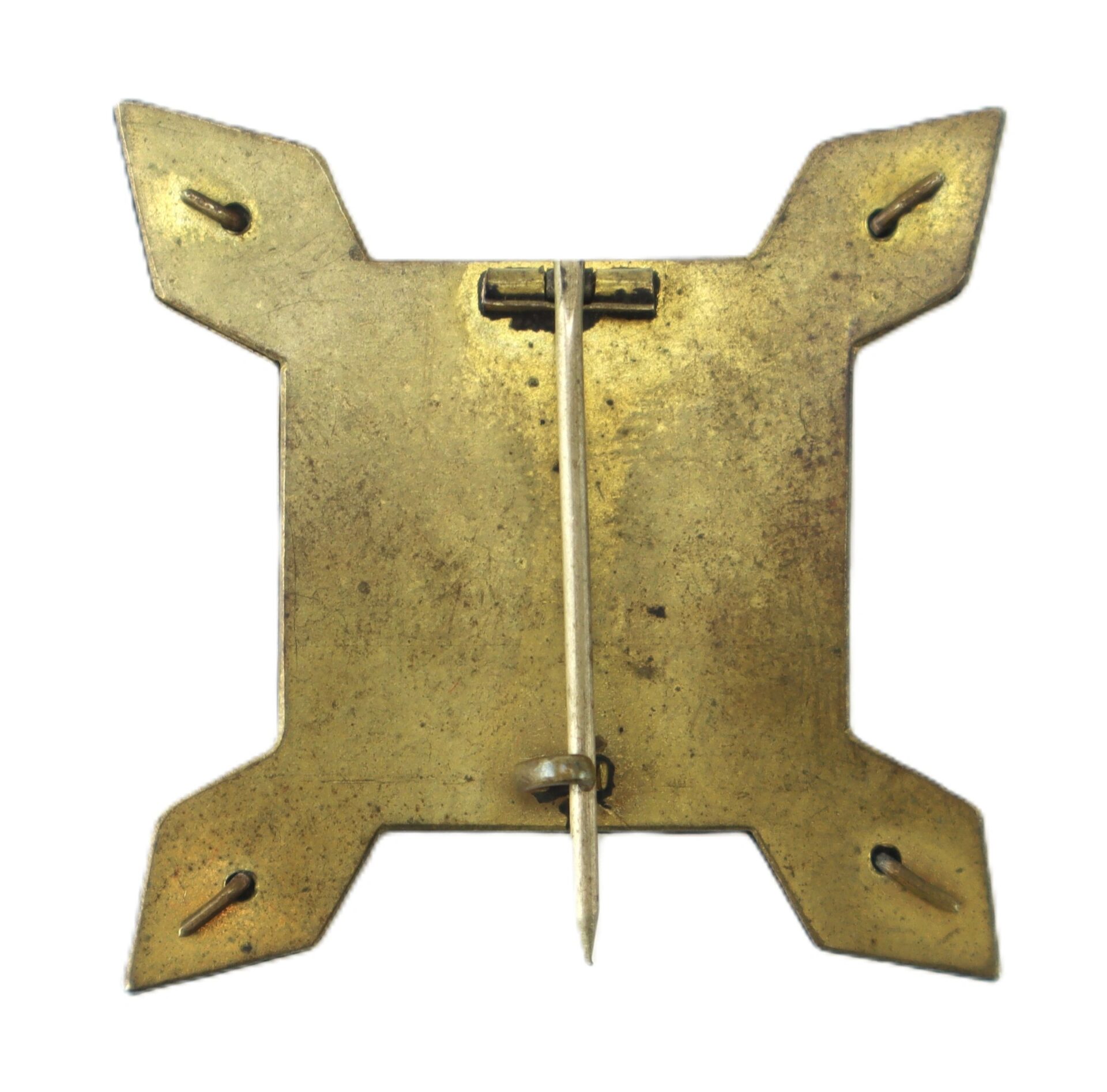 The 10th Corps Badge is a square brass pin with four pointed corners, a vertical clasp and hinge on the back, and four small slits near each corner.