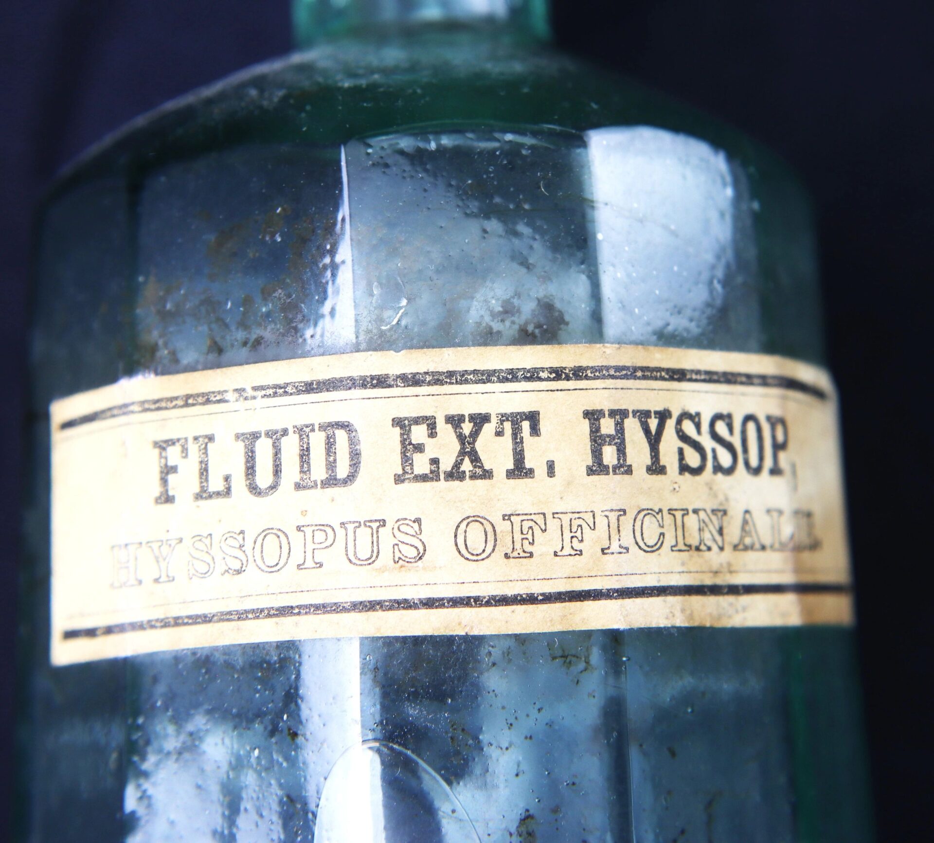 Close-up of an Apothecary Bottle labeled "Fluid Extract Hyssop" with a worn, slightly stained vintage label.