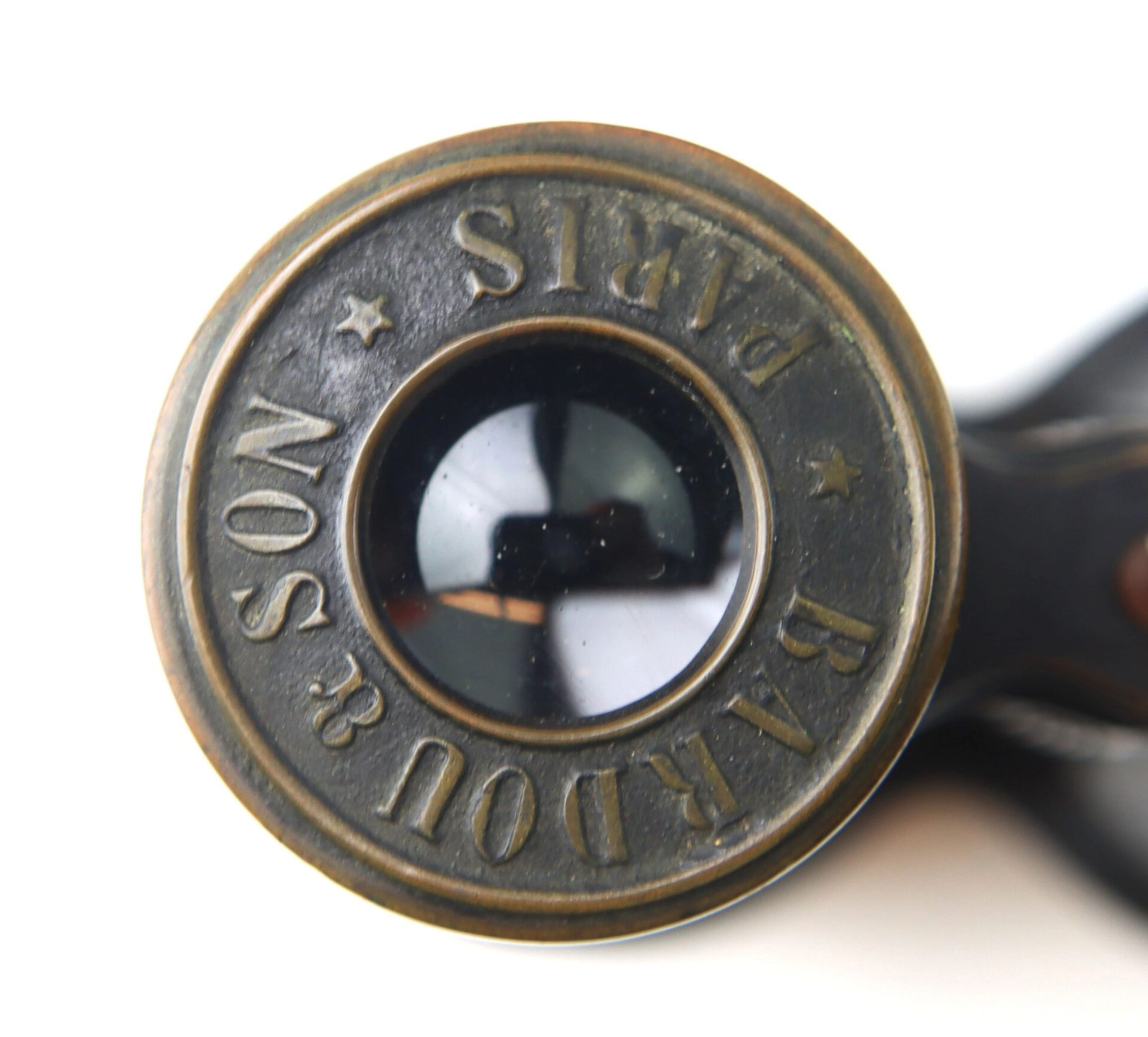Close-up of the eyepiece of Bardou & Son Paris Binoculars with "BARDOU & SON PARIS" engraved around the lens.