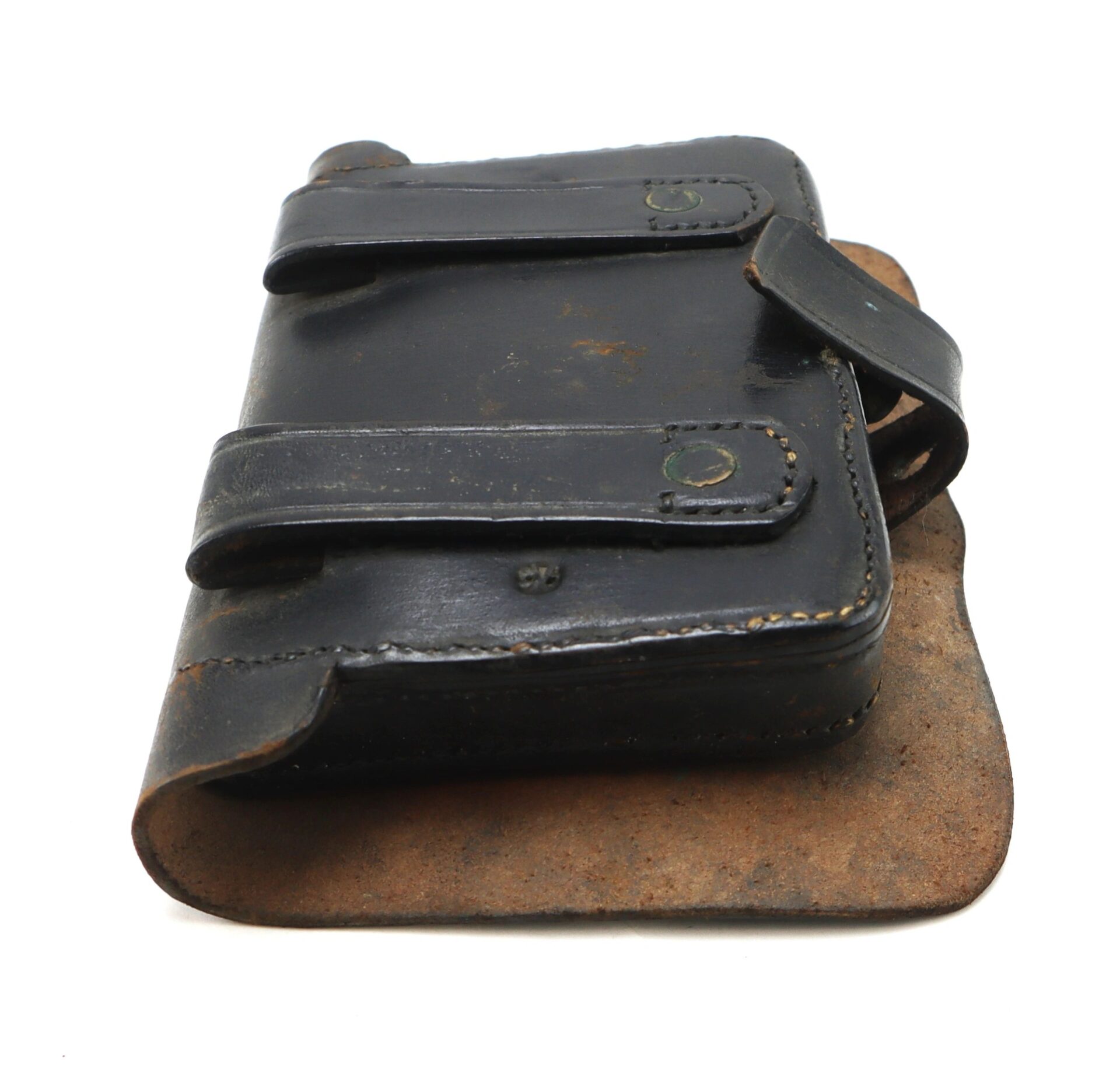 A Civil War Pistol Cartridge Box – Marked J. Davy & Co.; features a worn black leather pouch with two straps and snap buttons, attached to a brown, weathered backing.