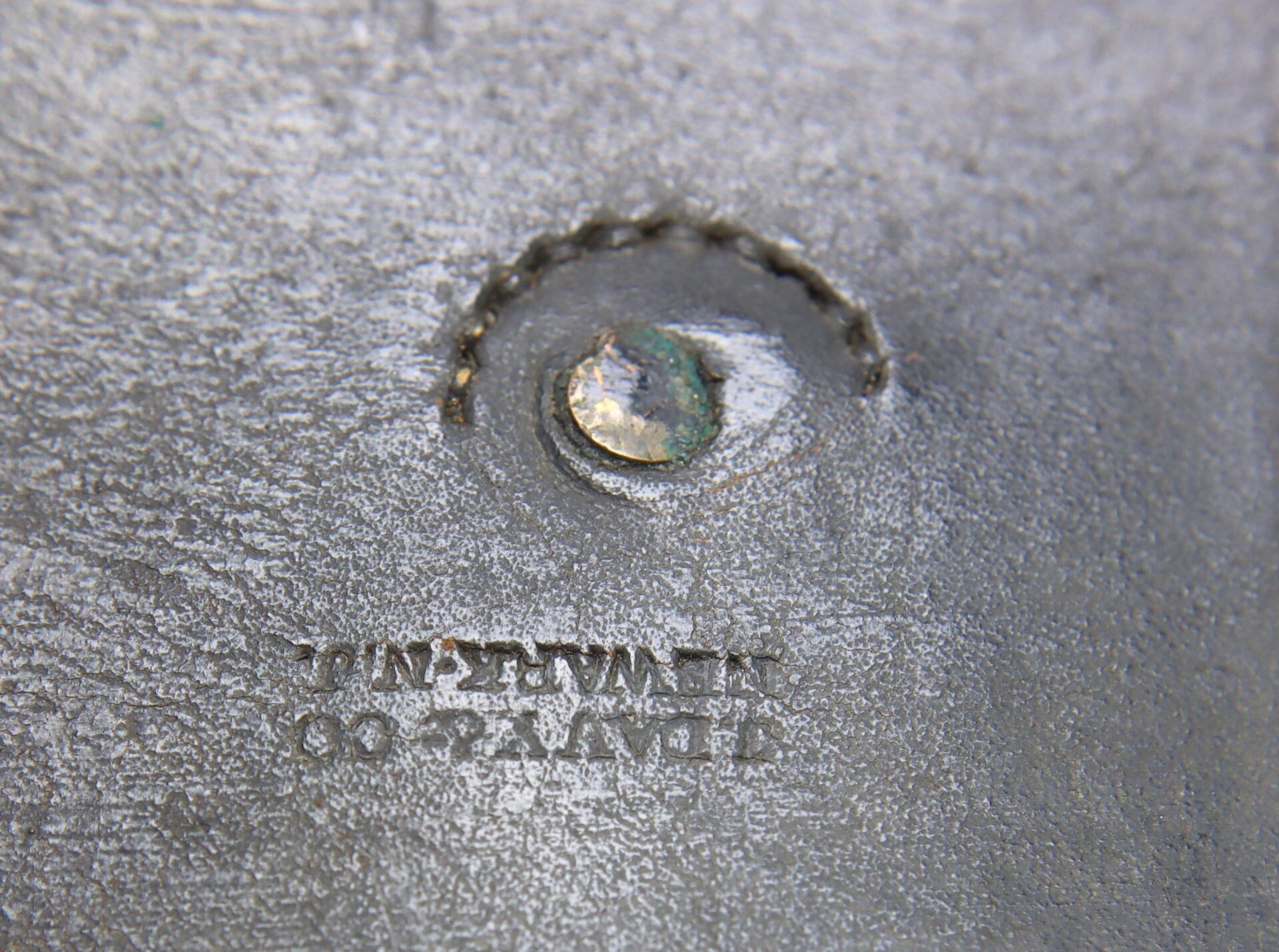 Close-up of a metal surface with a weld and a stamped marking that reads "J. Davy & Co." on a Civil War Pistol Cartridge Box.