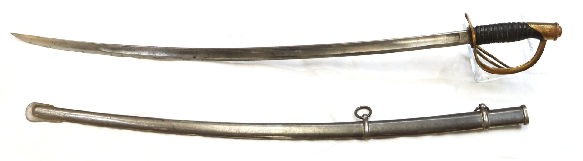A curved saber with a brass handguard and black grip, displayed above its matching metal scabbard with two mounting rings.