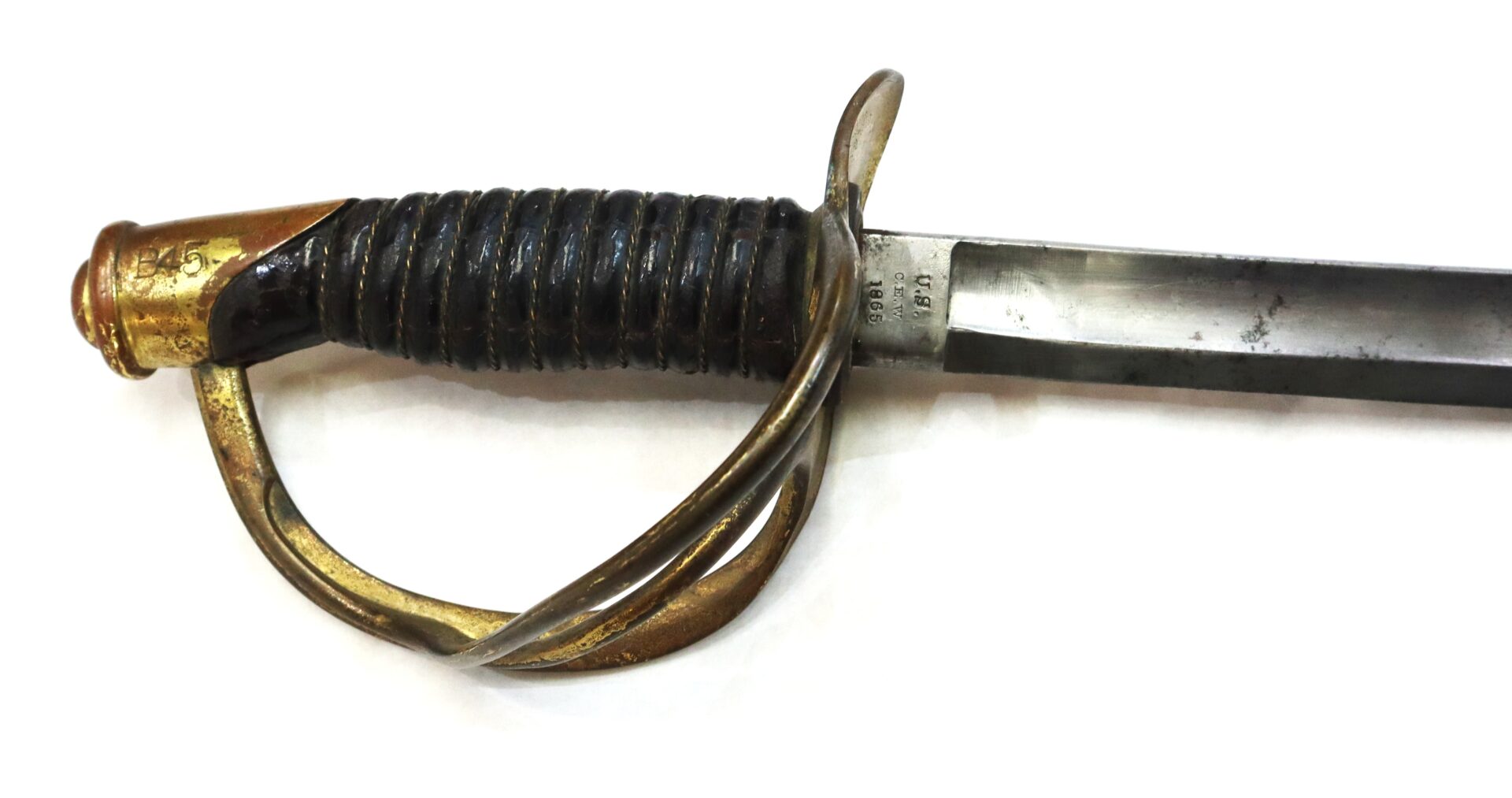 A close-up of a metal sword with a brass handguard and a black ribbed handle on a white background.