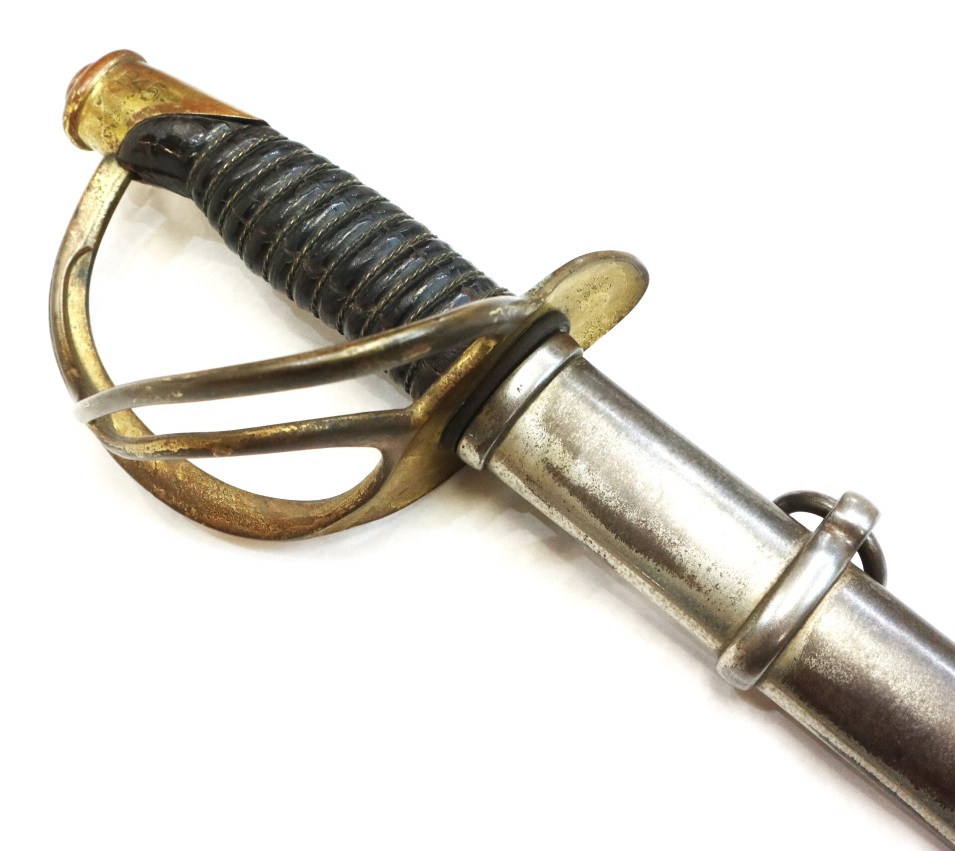 A close-up of an antique cavalry sword with a brass handguard, wrapped grip, and metal scabbard, set against a white background.