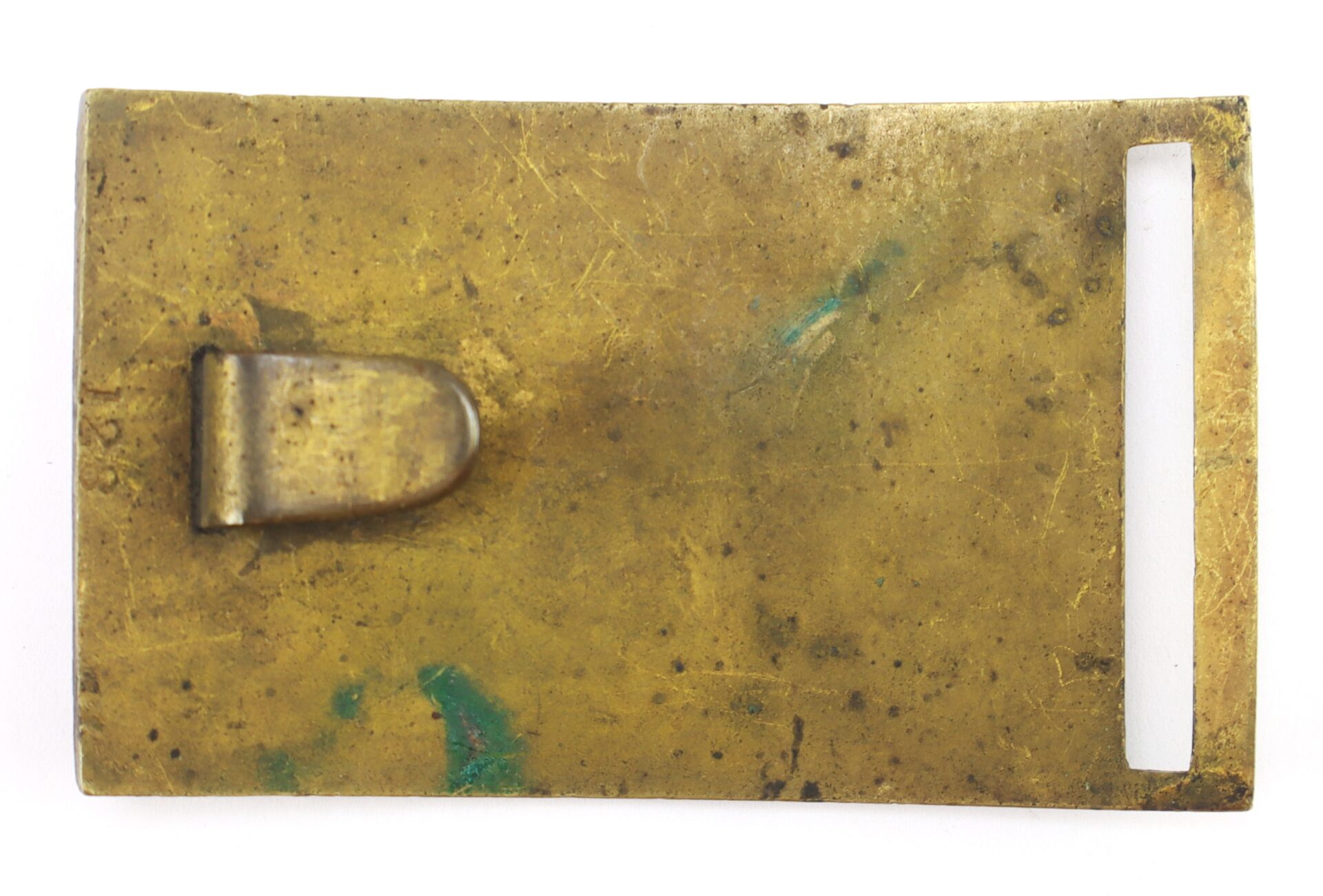 Rectangular brass belt buckle with a clip and a rectangular slot, showing signs of tarnish and green oxidation.