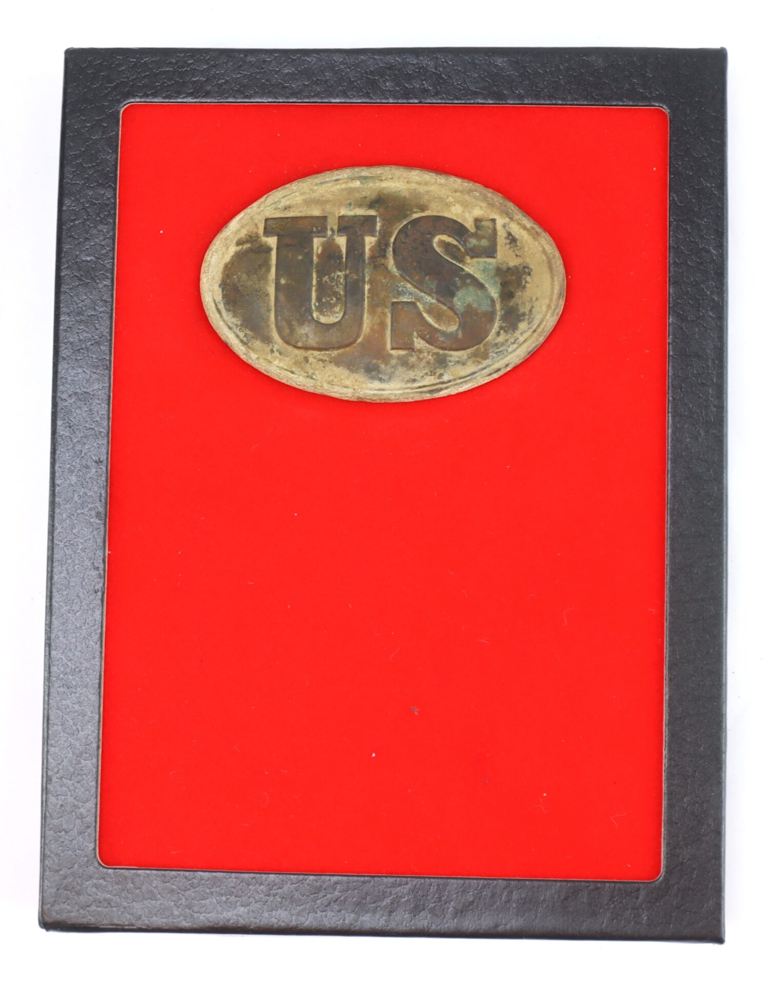 An old brass "US" oval belt buckle displayed in a black frame with a red background.