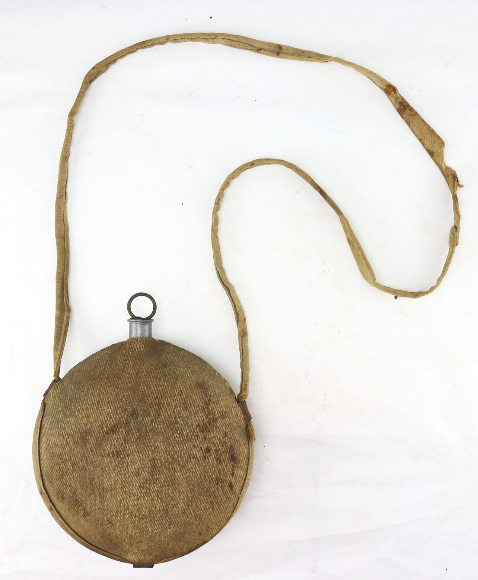 A round, vintage canteen with a fabric cover and a long, worn shoulder strap, displayed on a white background.