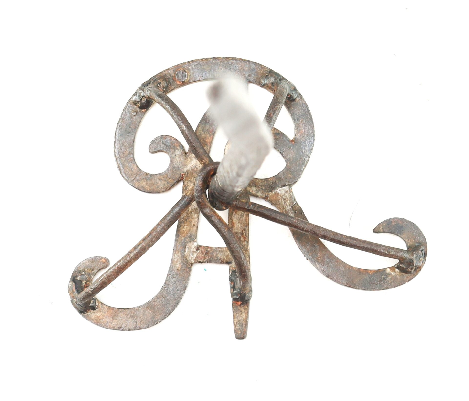 A wrought iron decorative bracket with scrollwork, viewed from above on a white background.
