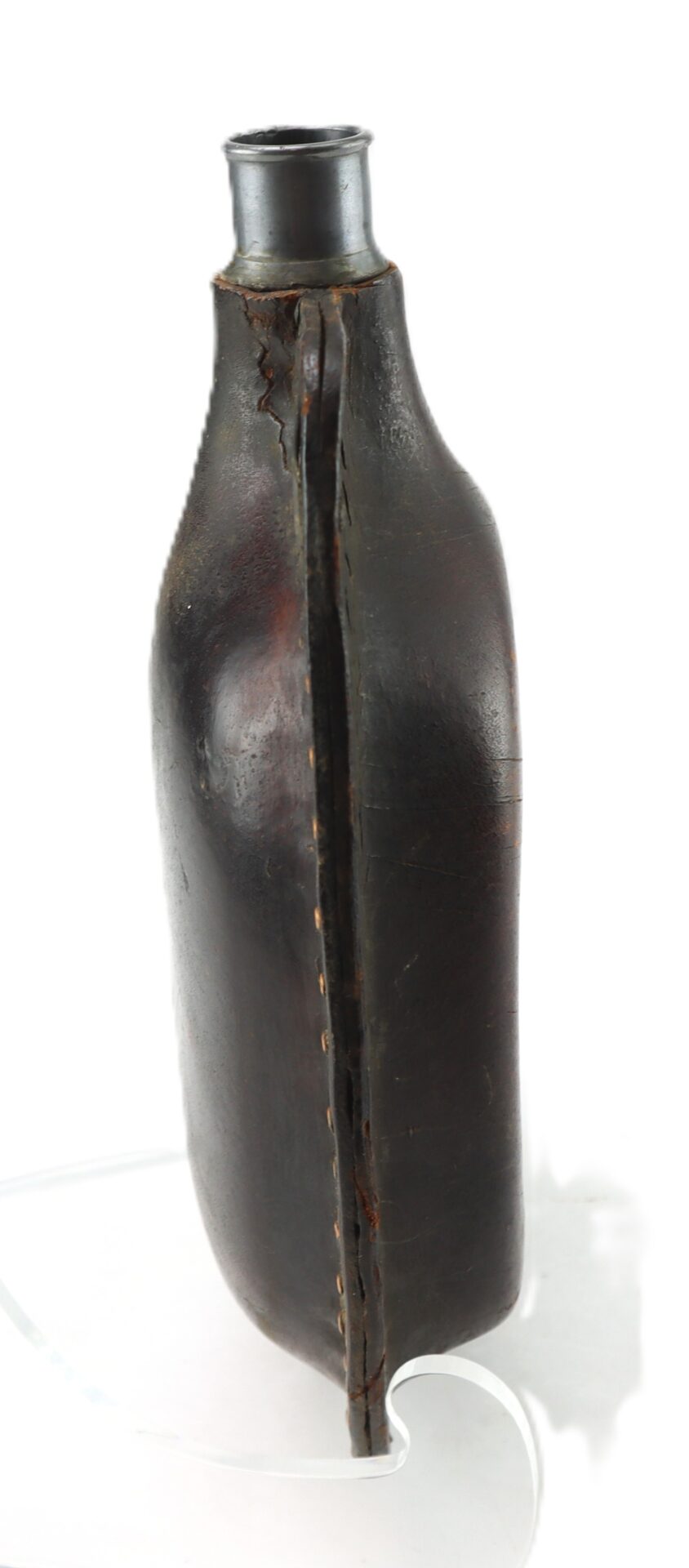 A vintage dark leather canteen with visible stitching along the seam, a metal neck, and signs of wear.