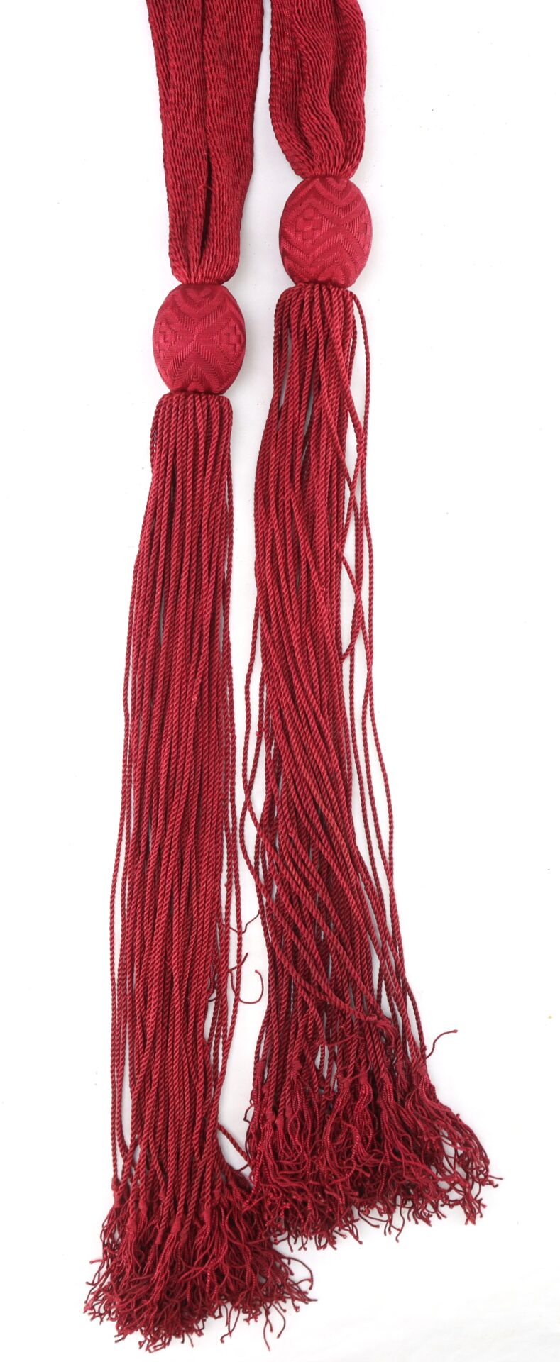 Two long, red braided tassels with knotted ends and decorative tops, displayed against a white background.