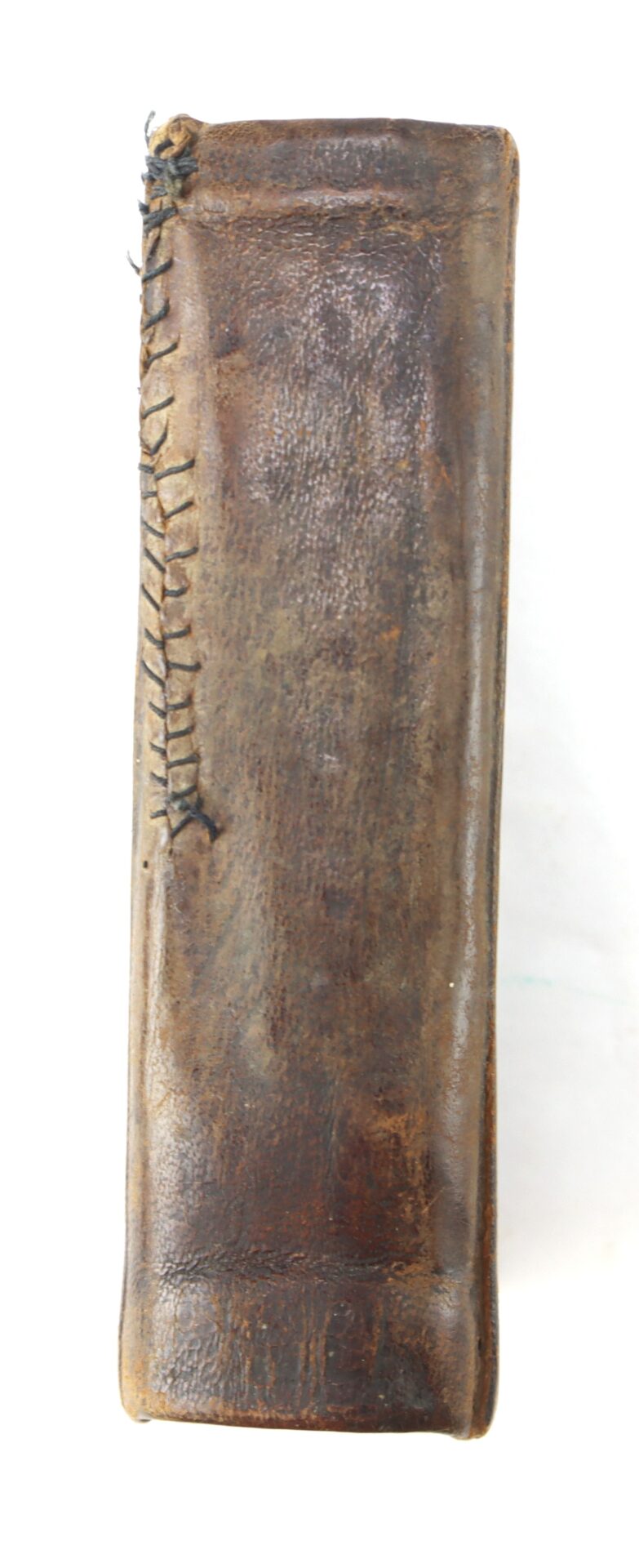 A close-up of the Confederate Bible’s aged, brown leather spine shows visible hand-stitched black thread along one edge.