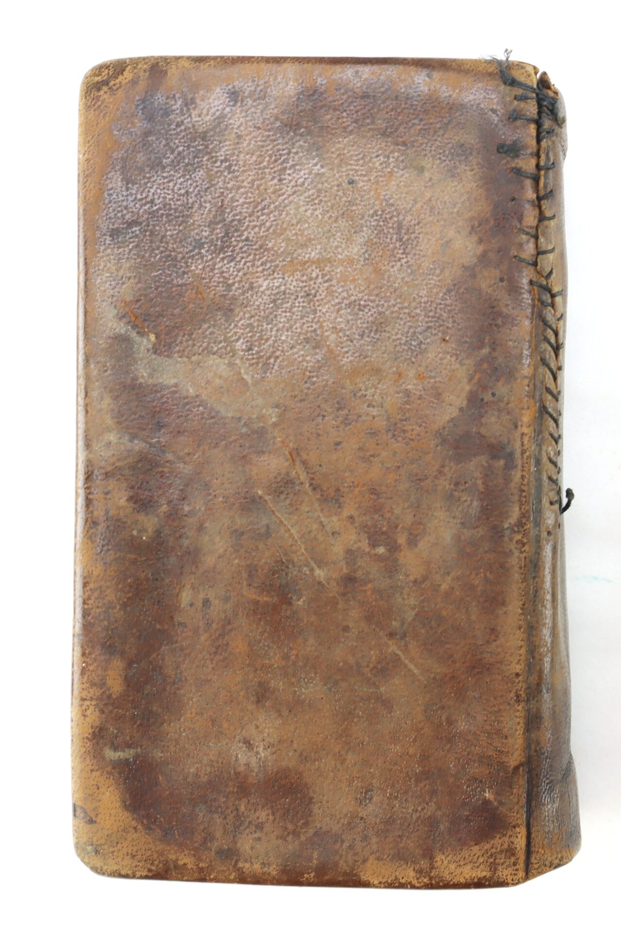 A worn, brown leather-bound Confederate Bible with visible scratches and hand-stitched repairs along the spine.