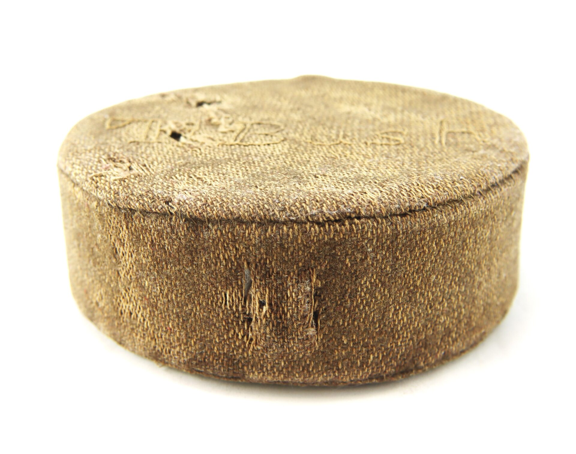 A round, worn fabric-covered hatbox with visible stitching and fraying on the sides, set against a white background.