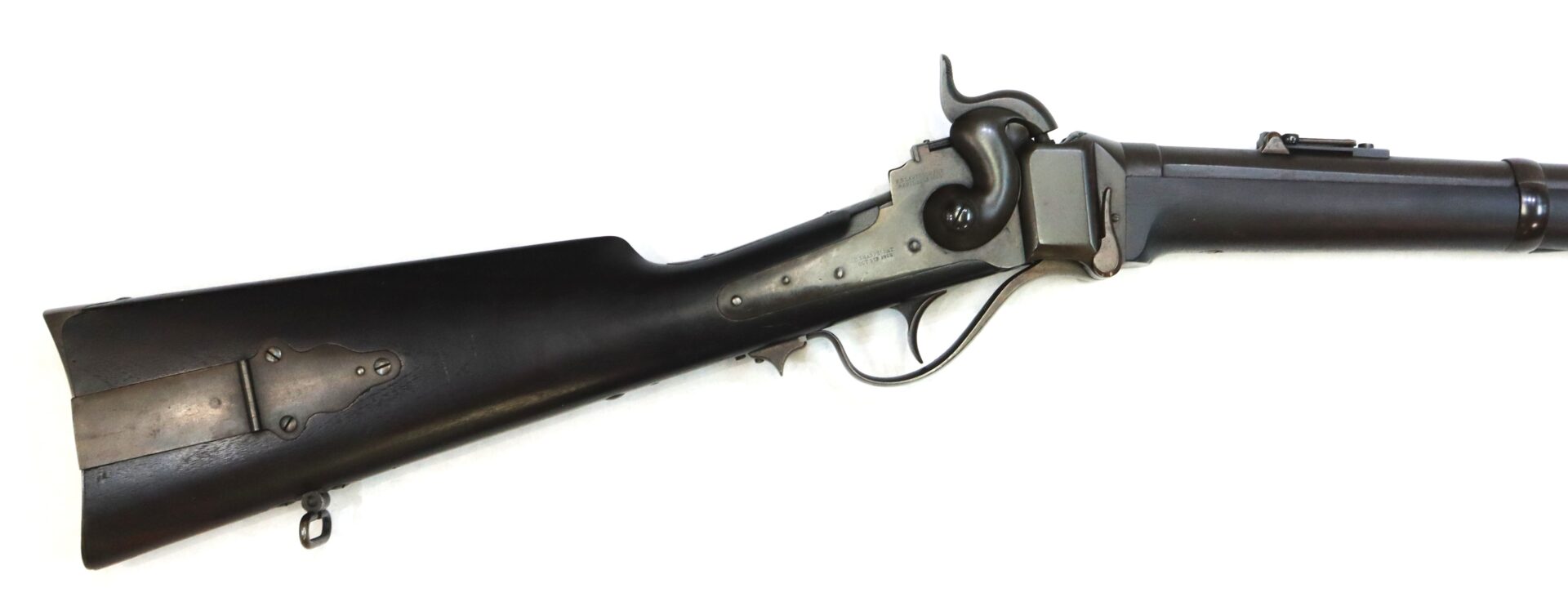 A side view of a black and silver antique rifle with a wooden stock, lever action, and metal hardware, photographed against a white background.