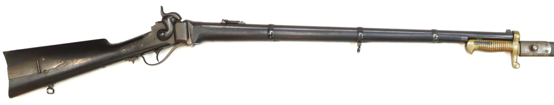 A vintage black rifle with a wooden stock and a bayonet attached to the end of the barrel, displayed on a white background.