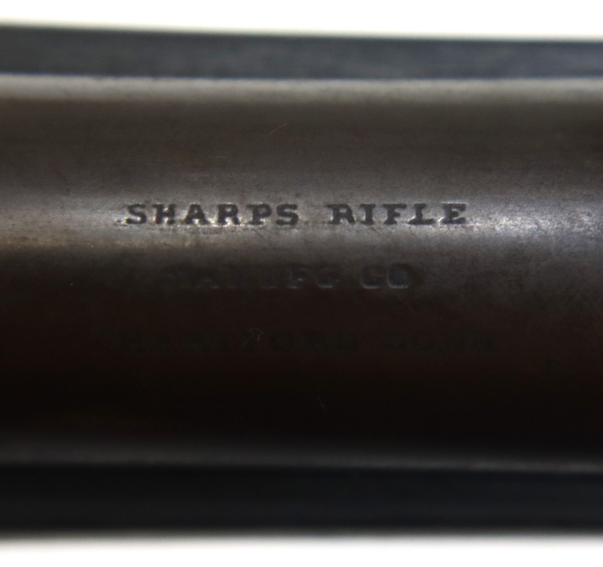 Close-up of a metal surface engraved with "SHARPS RIFLE" and additional text indicating "SHARPS CO" and "HARTFORD CONN.