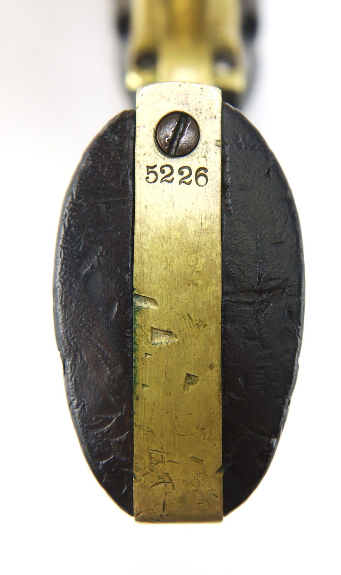 Close-up view of a brass and dark metal object with the number 5226 engraved on the brass strip, secured by a flathead screw.