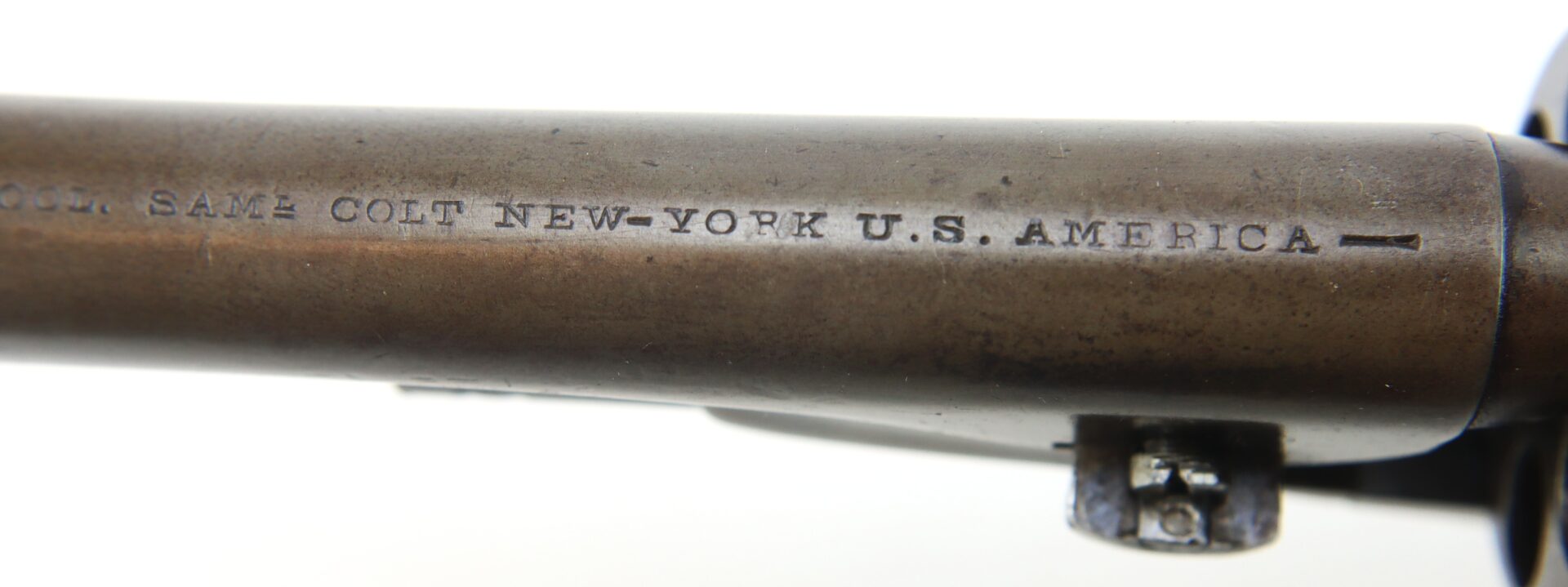 Close-up of engraved Colt firearm barrel.