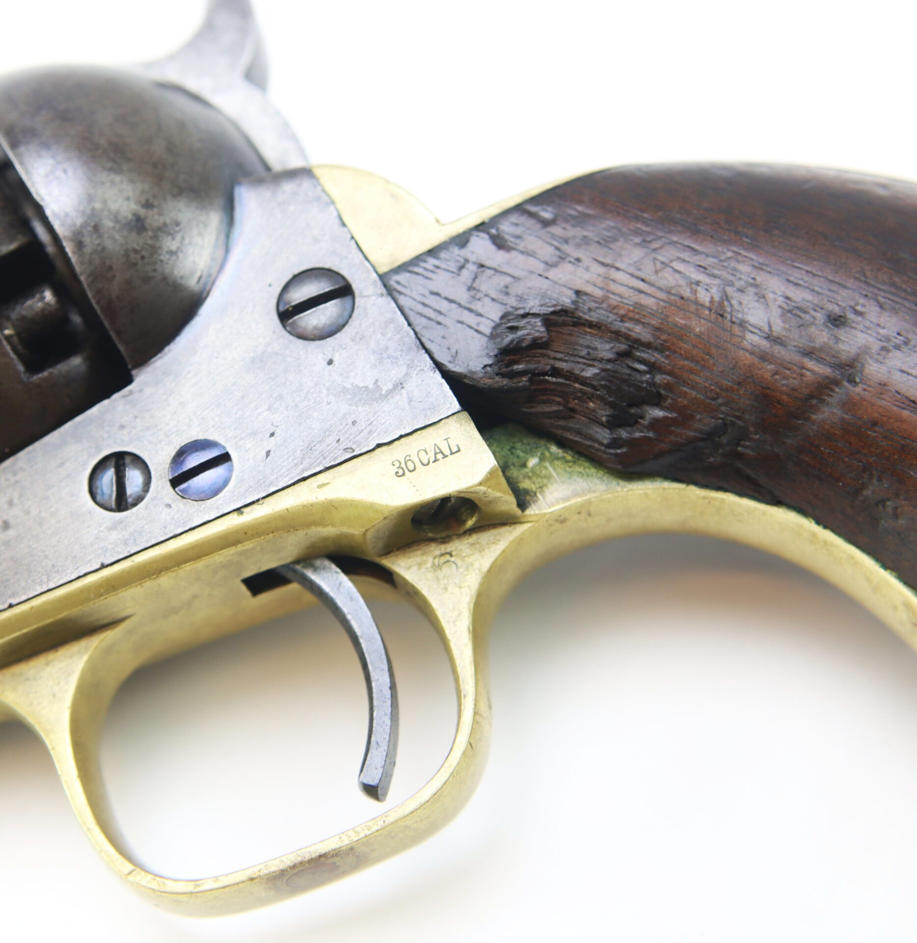 Close-up of a vintage revolver with a wooden grip, metal frame, and "36 CAL" engraved near the trigger.