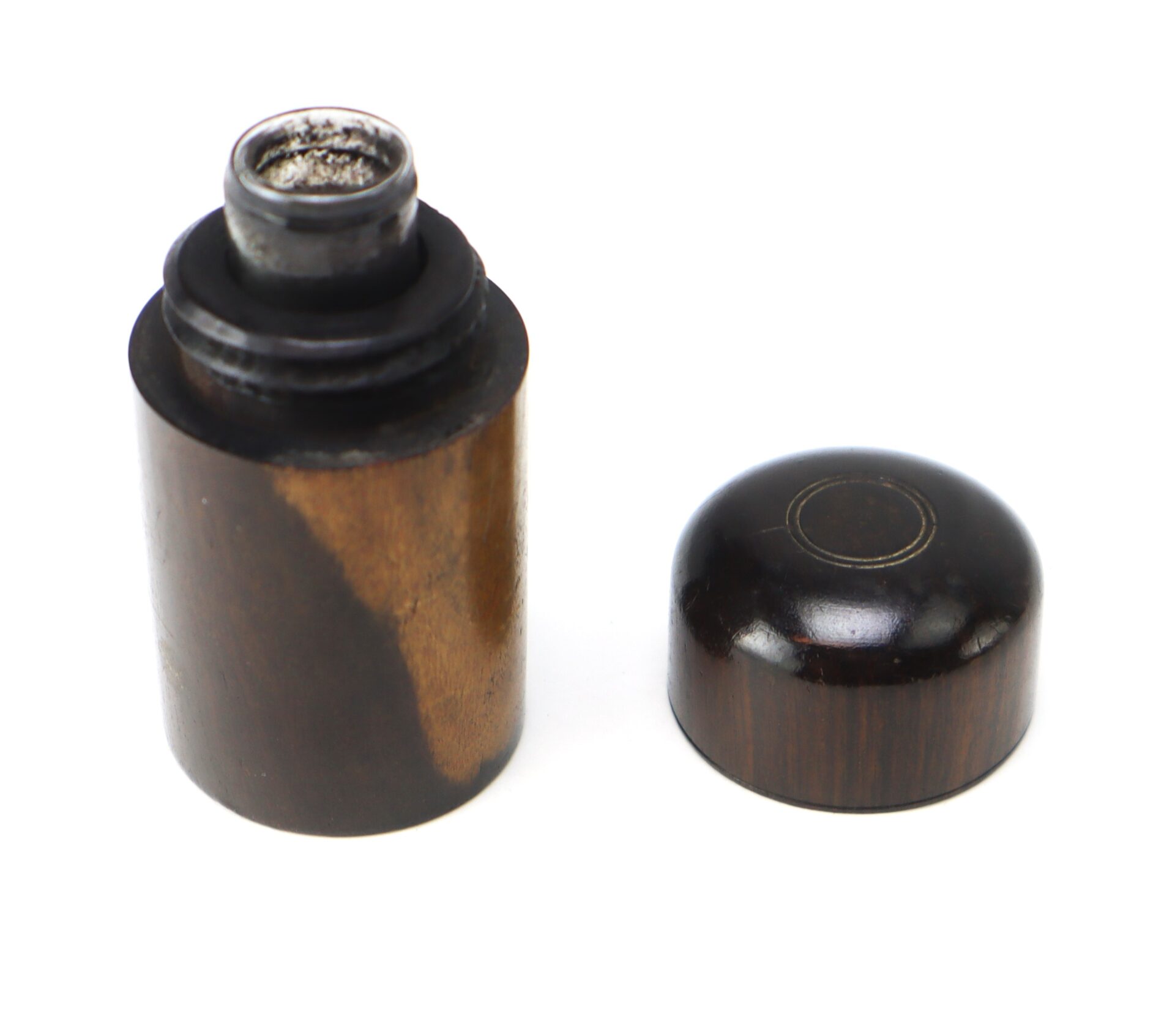A small cylindrical wooden container with a removable lid, shown open and revealing a metal interior.