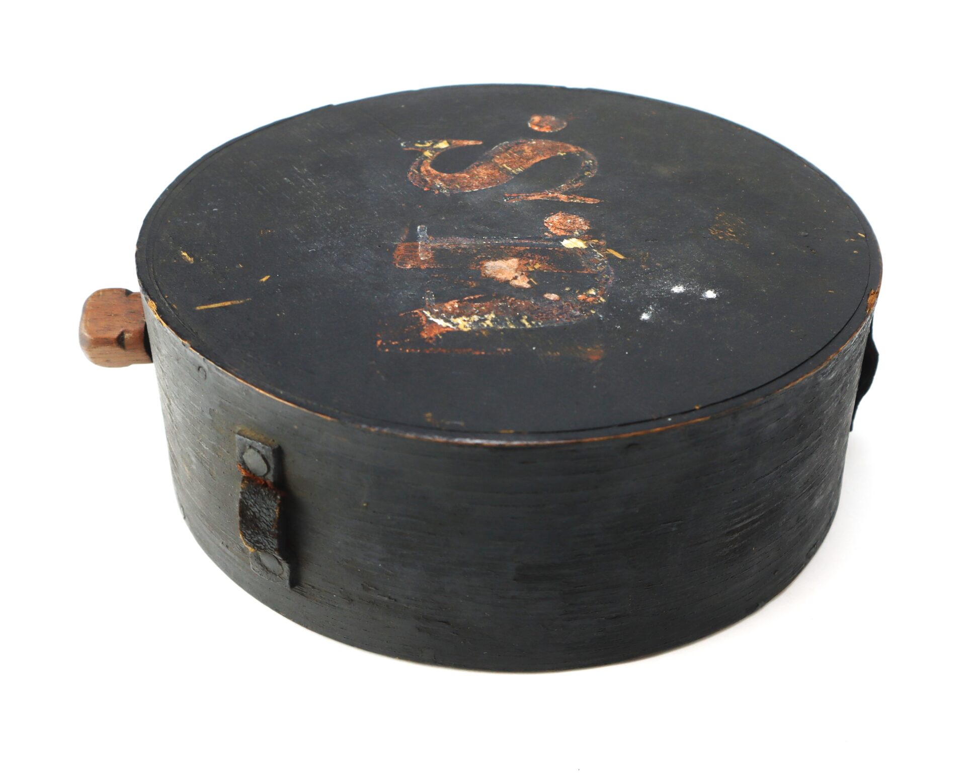 A round, black wooden Mexican War Cheesebox Canteen with a lid, a faded painted label, and two side handles made of metal and wood.