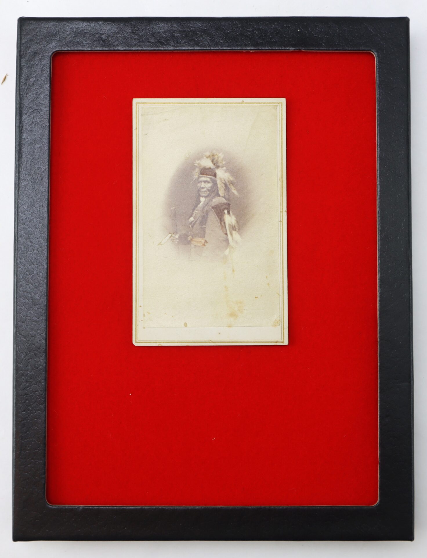 A sepia-toned vintage portrait photograph is centered on a bright red background within a black rectangular frame.