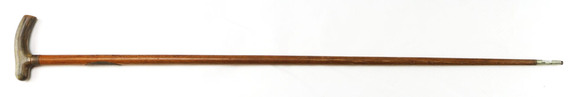 A wooden cane with a curved handle and a metal tip, photographed on a white background.