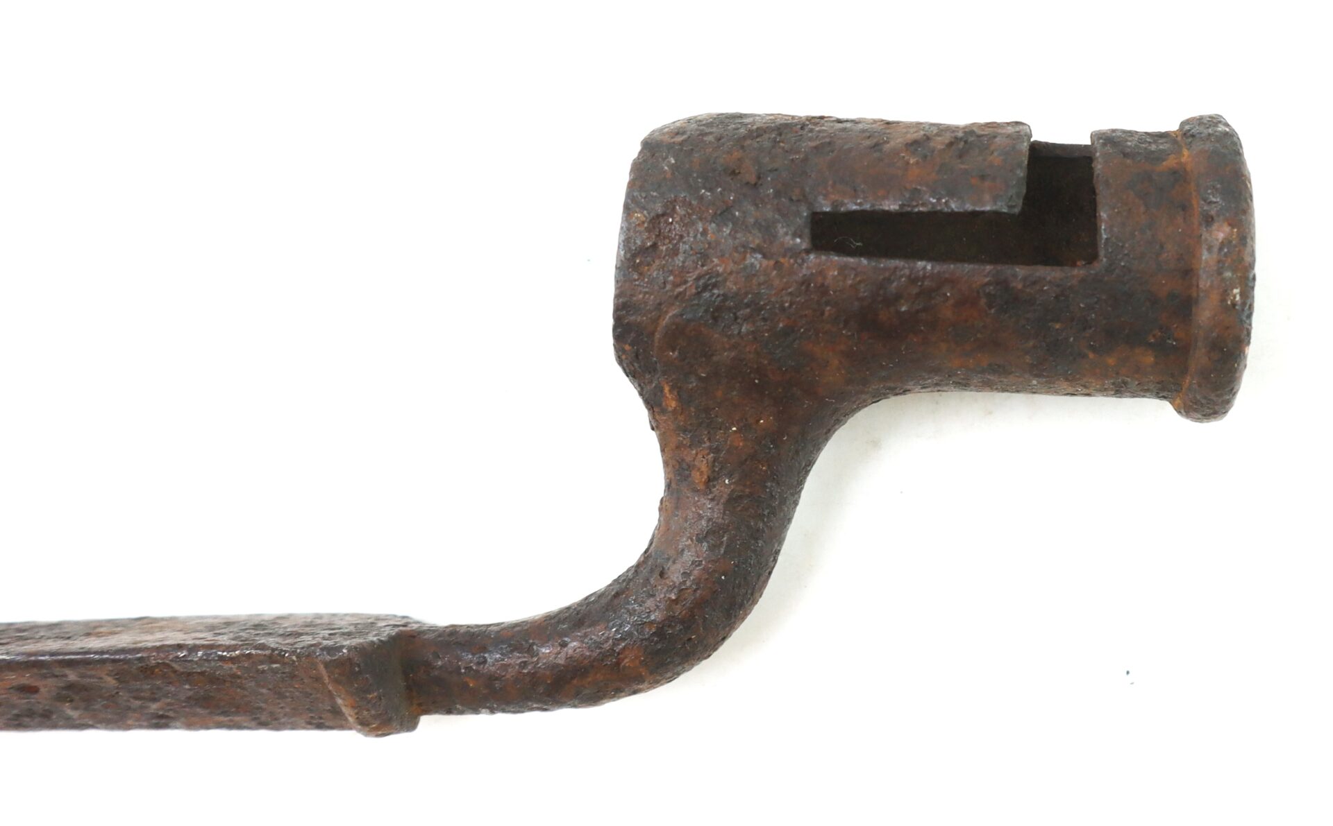 Rusty, old metal tool with a cylindrical, notched end and a curved handle, set against a plain white background.