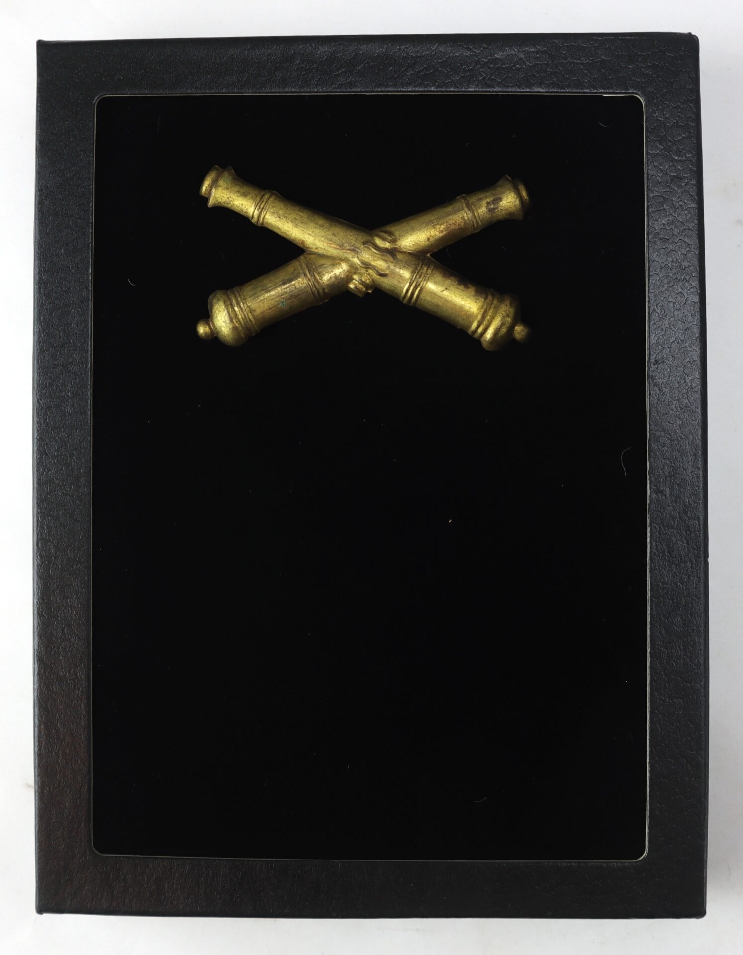 A pair of crossed gold cannons displayed on a black background inside a black frame.