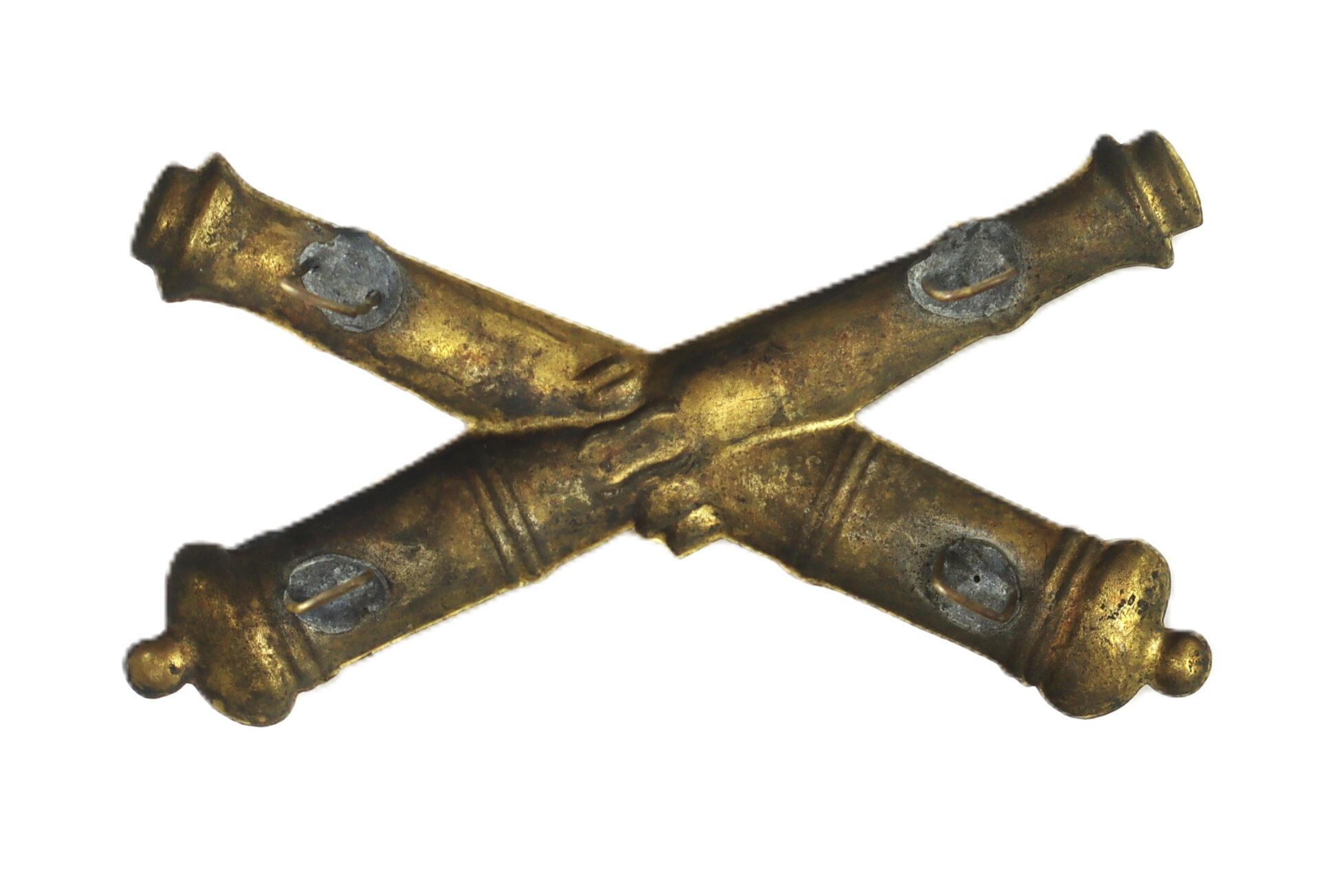 A brass insignia featuring two crossed cannons, isolated on a white background.