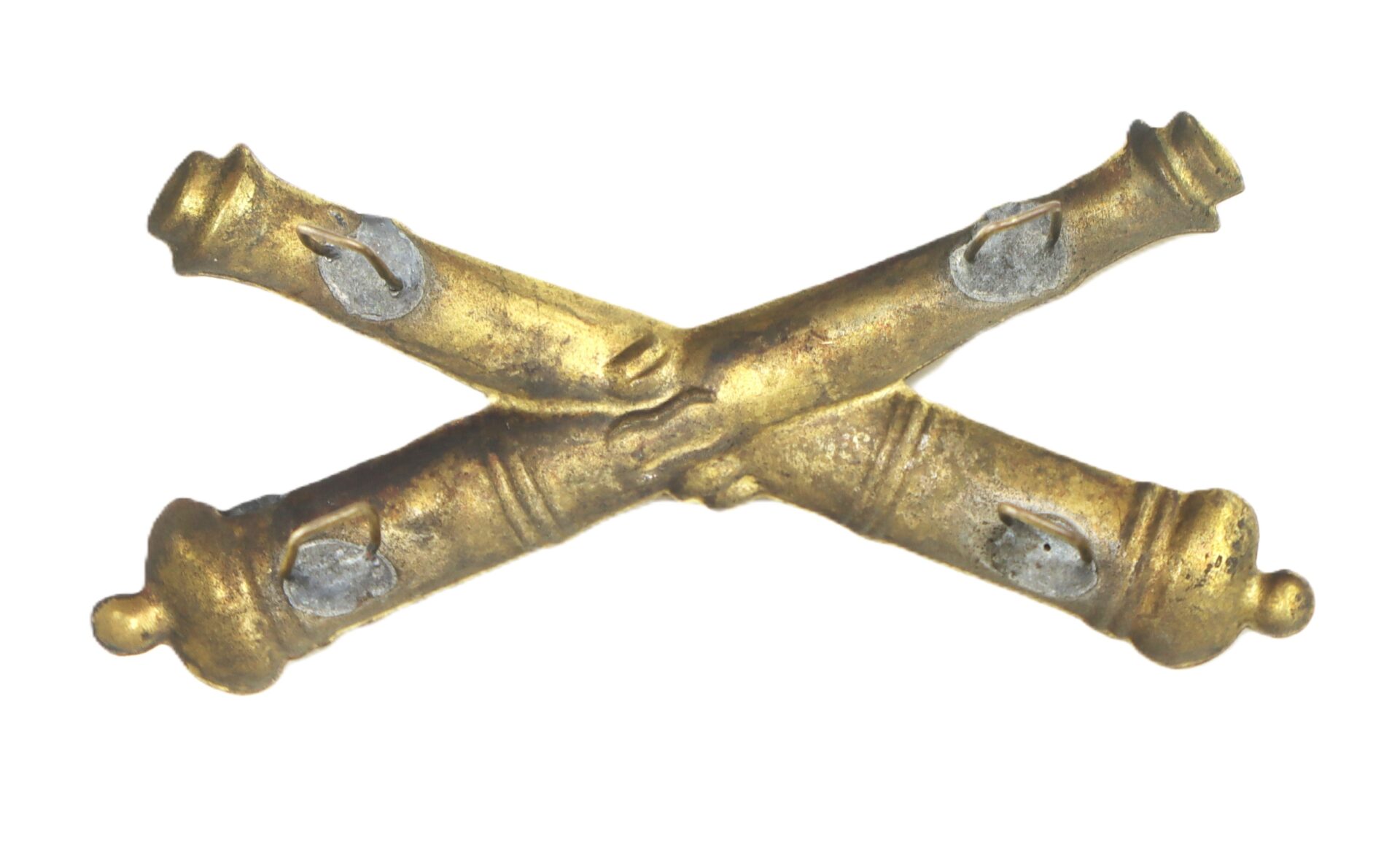 A brass insignia featuring two crossed cannons, typically used to represent artillery units in military organizations.