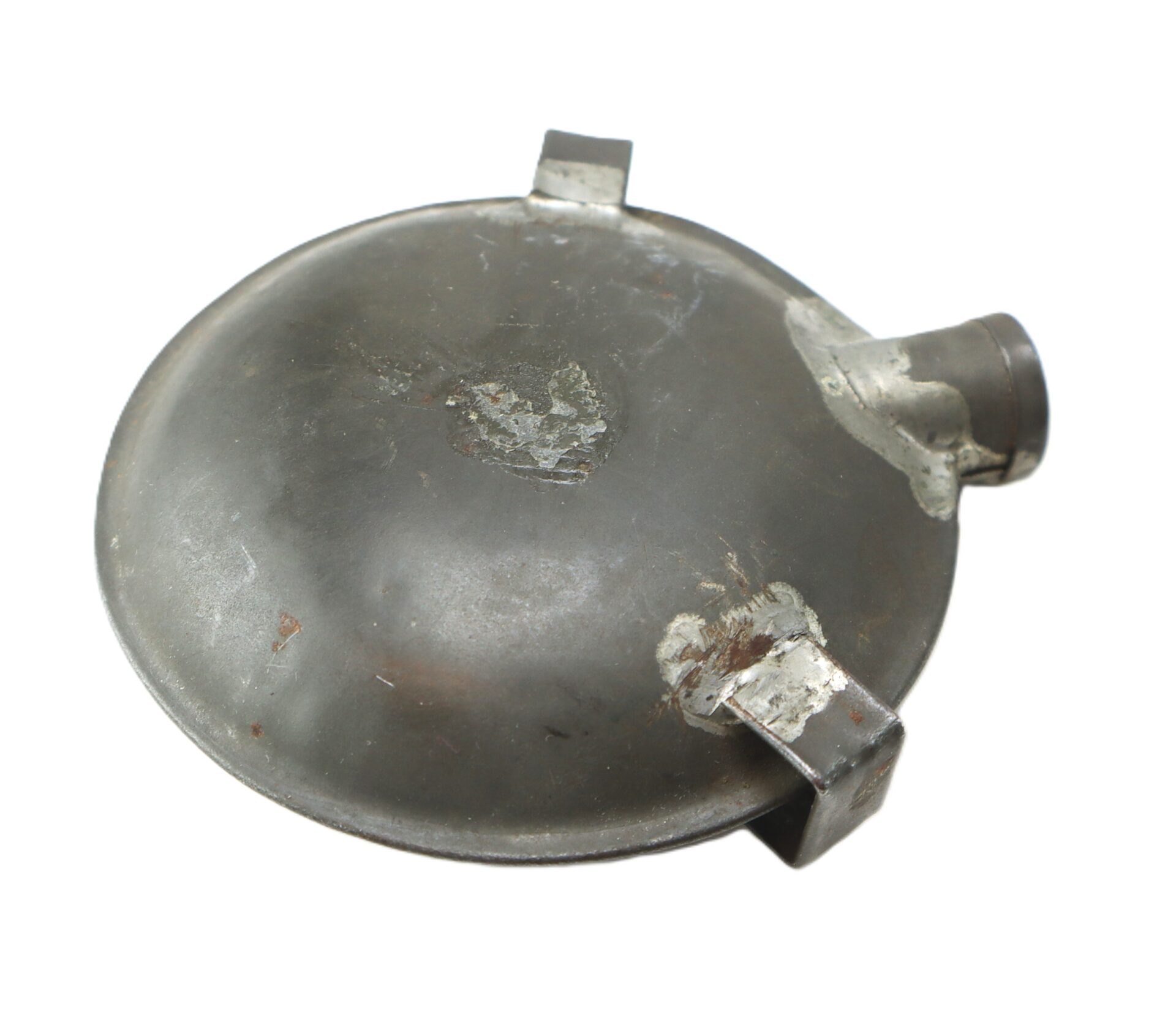 A worn, round metal object with a spout and two welded brackets, photographed against a white background.