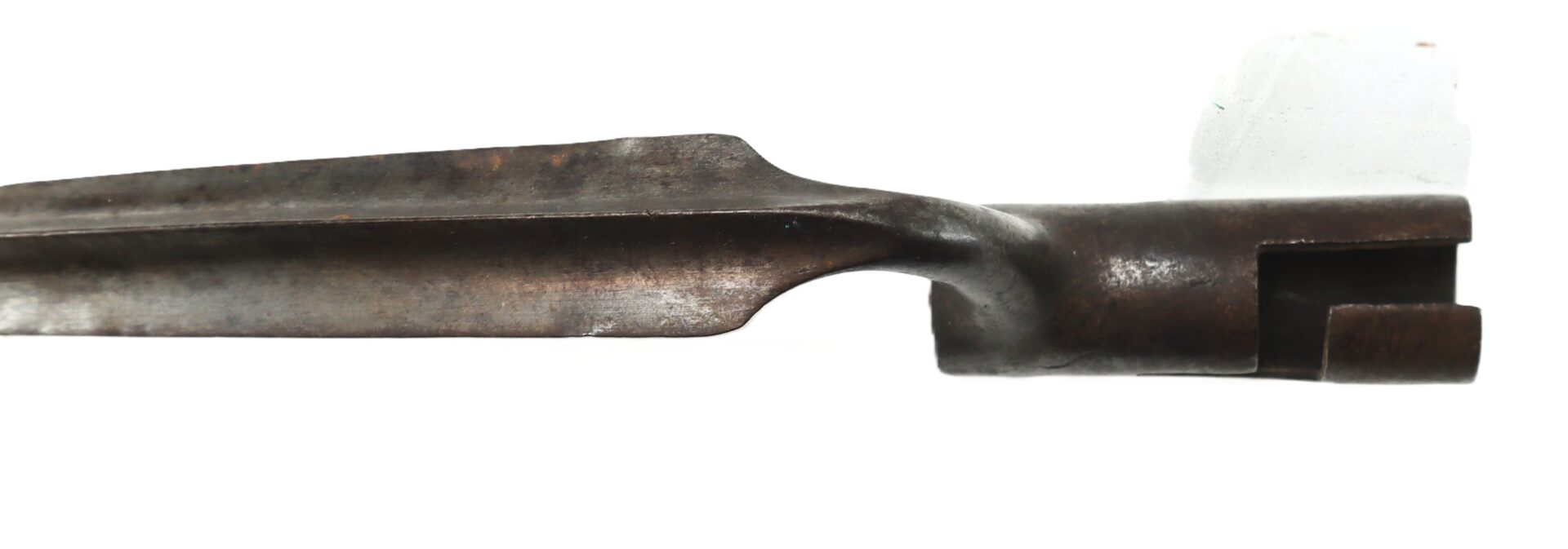 A close-up view of an old, rusted metal bayonet with a grooved blade and a socket for mounting.