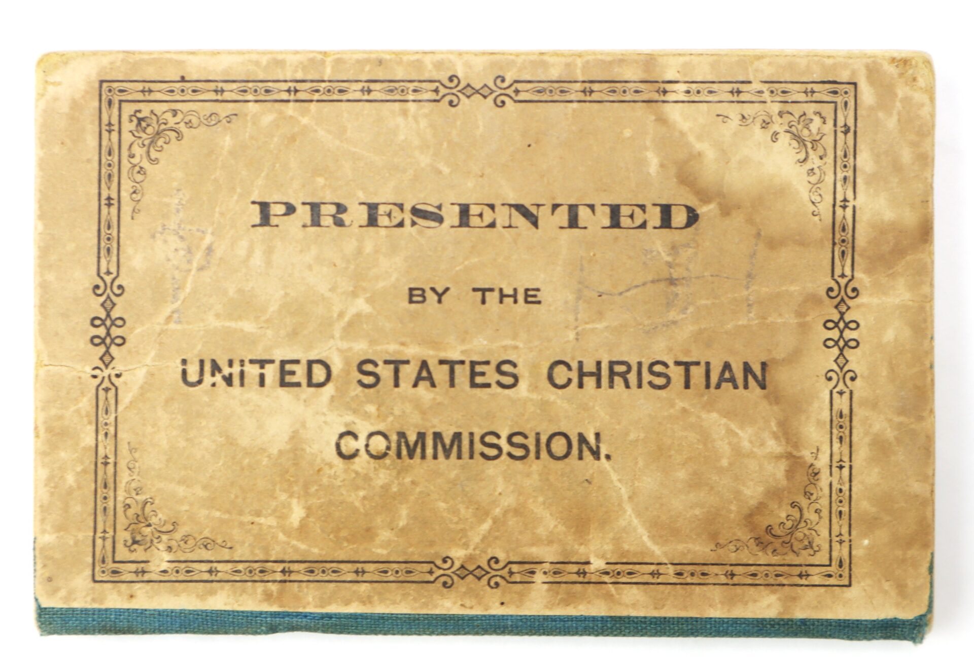 A worn book cover with ornate borders and text reading "Presented by the United States Christian Commission.