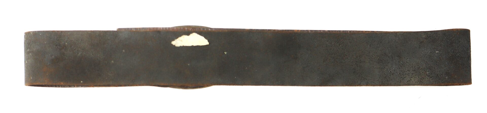 A worn, dark metal strip with a slight curve and a small patch of white discoloration near the center.