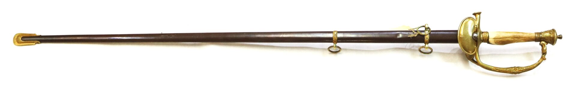 A decorative sword with a brass hilt and antler handle, sheathed in a dark scabbard with brass fittings and two suspension rings.